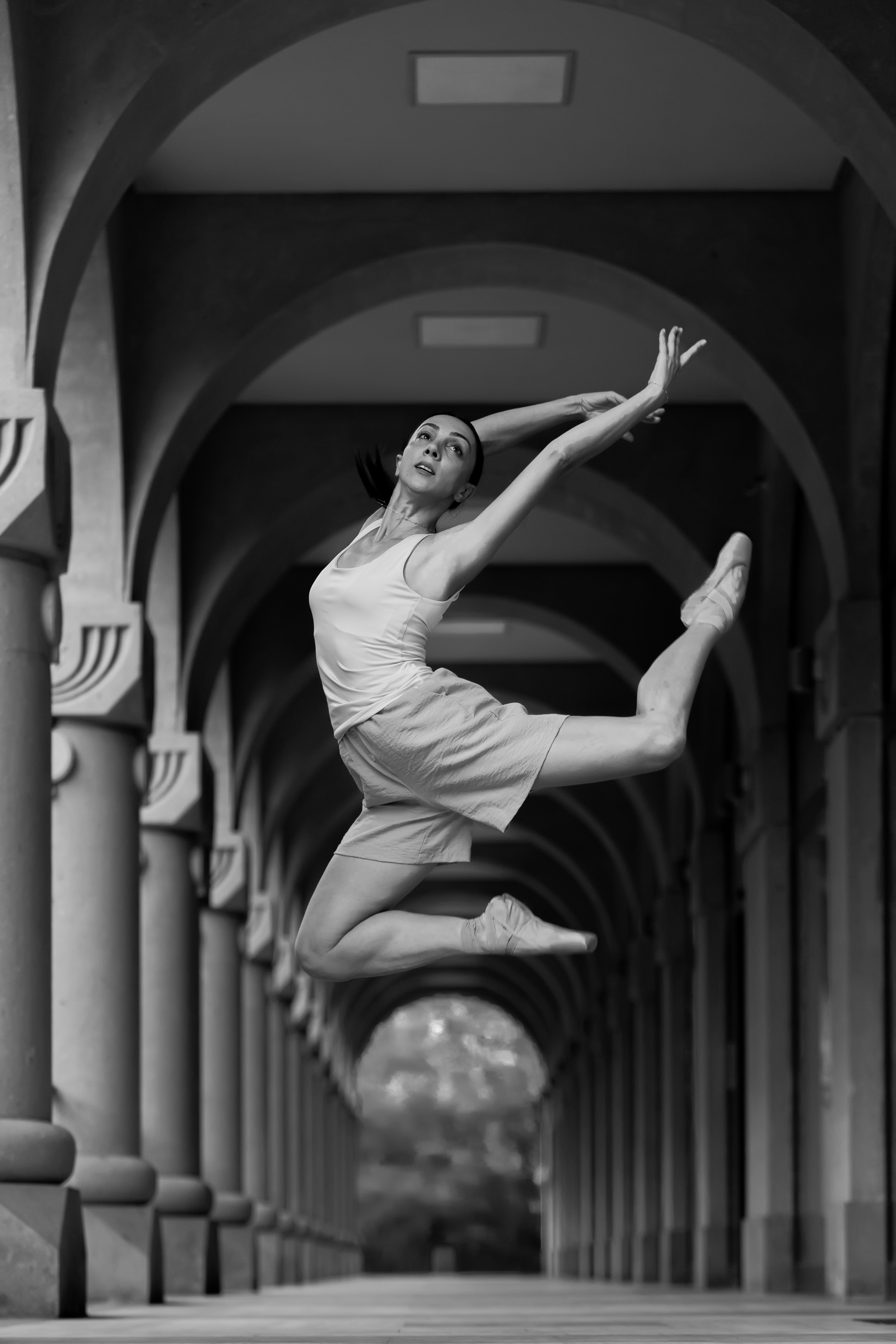 A woman is jumping in the air in a hallway