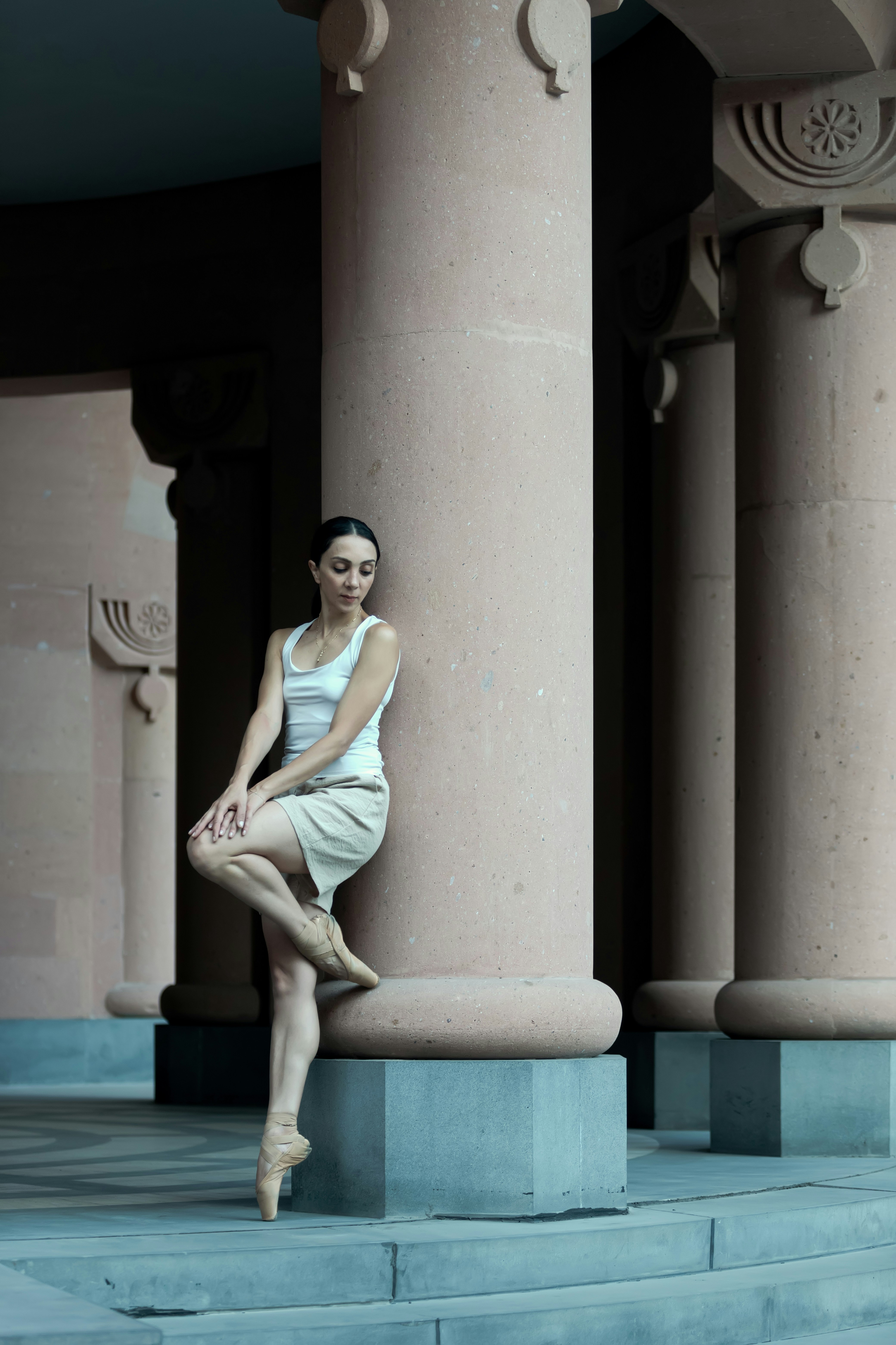 A woman in a white dress is sitting on some steps