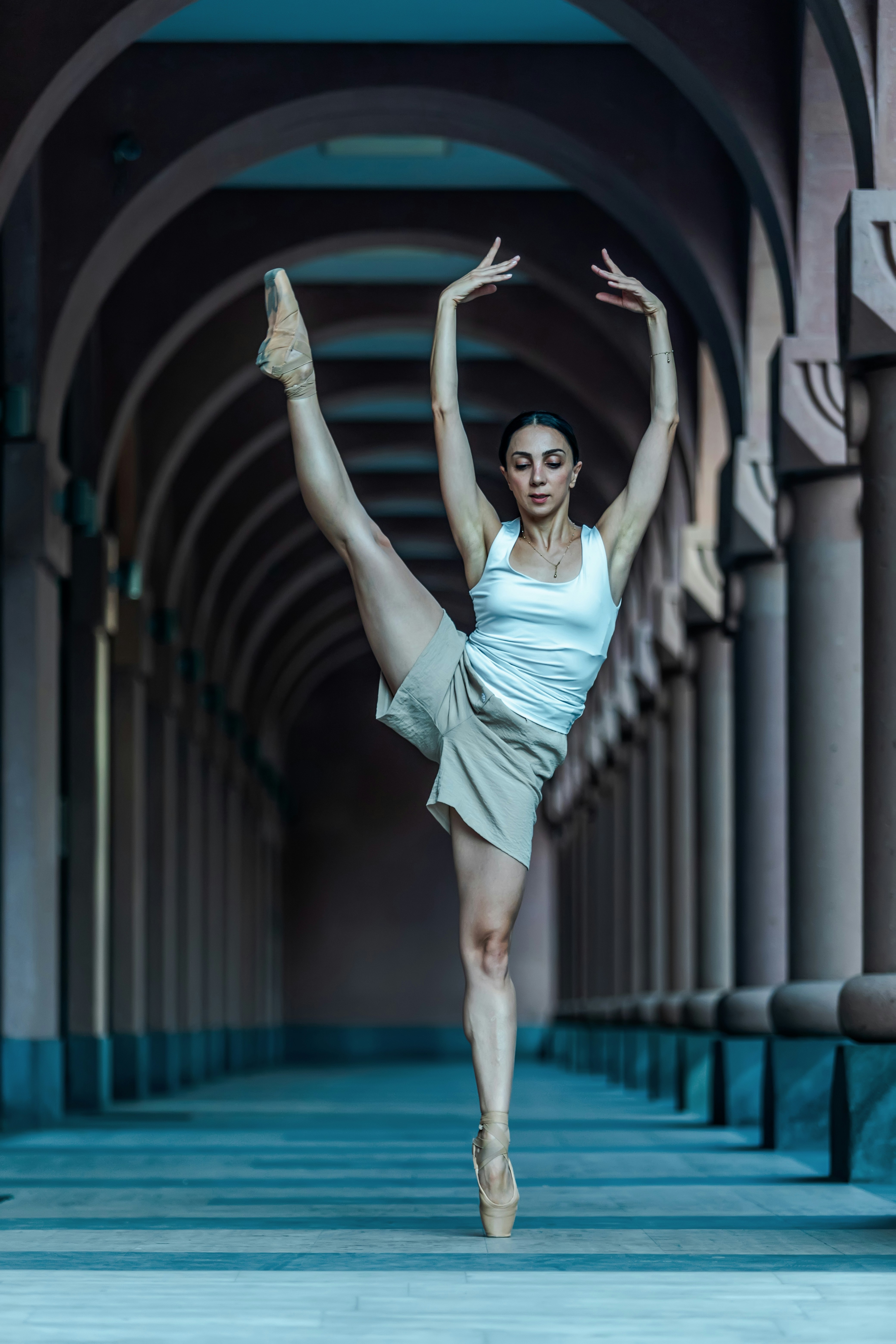 A woman in a white top and tan skirt is dancing