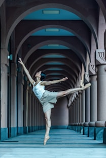 A ballerina in a white dress is doing a ballet move