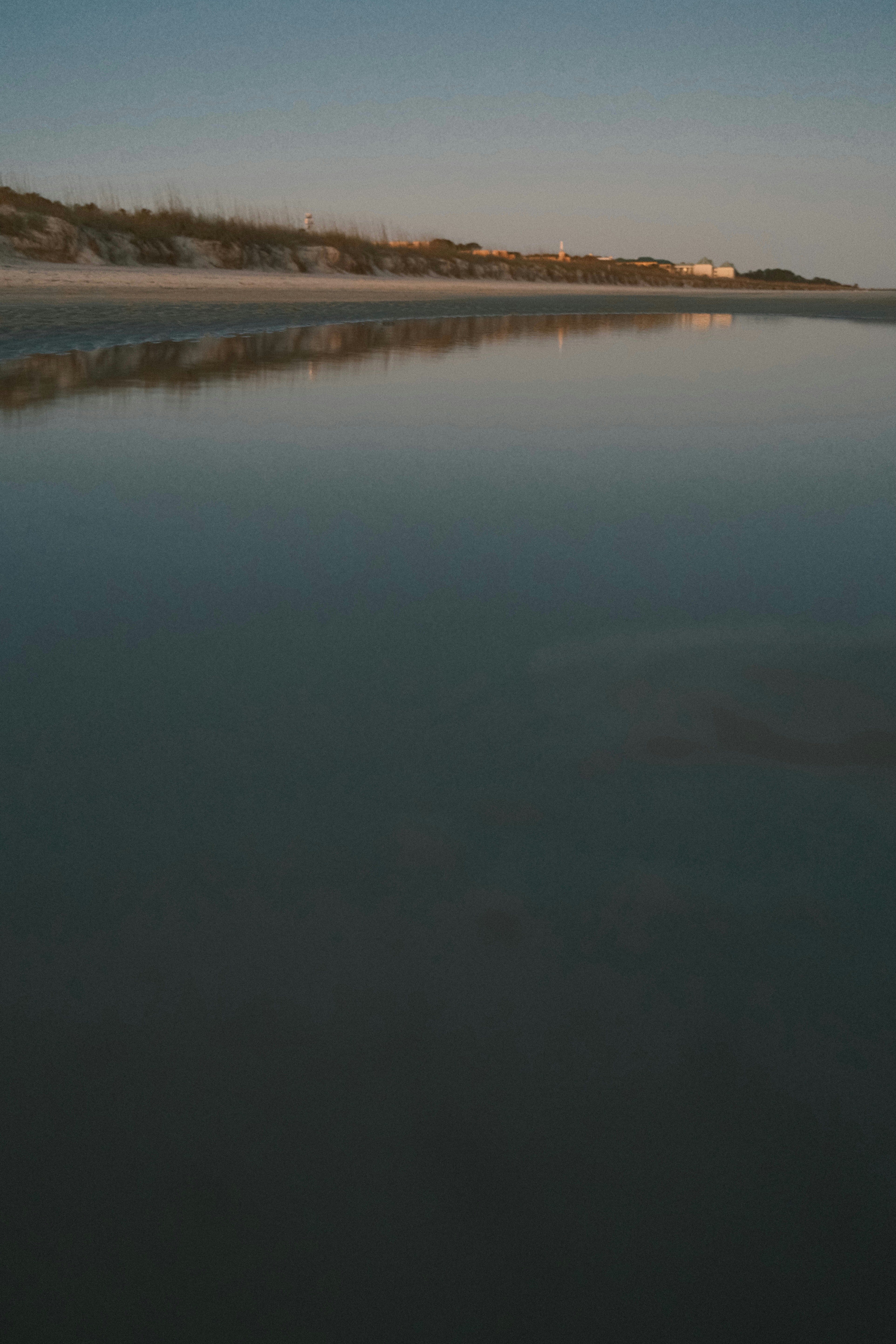A large body of water sitting next to a sandy beach