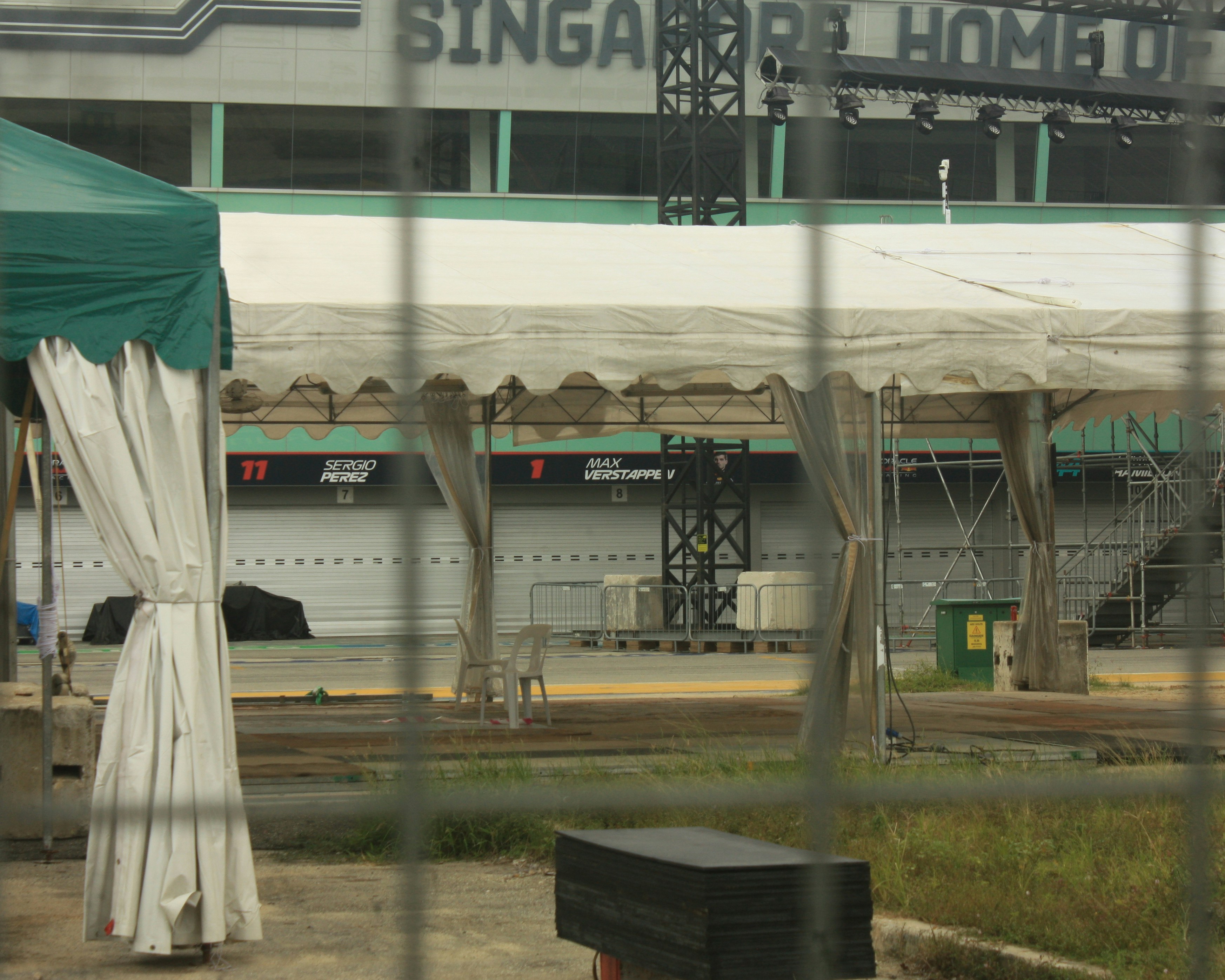 Tenda hijau dan putih duduk di depan sebuah gedung