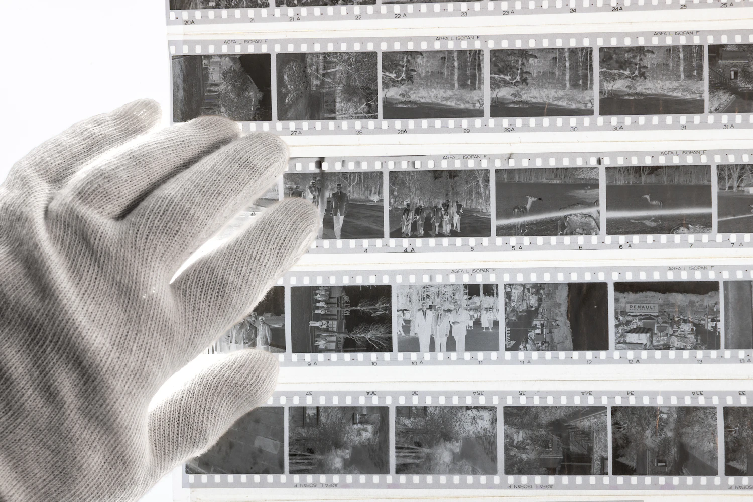 White-gloved hands carefully inspecting archival film