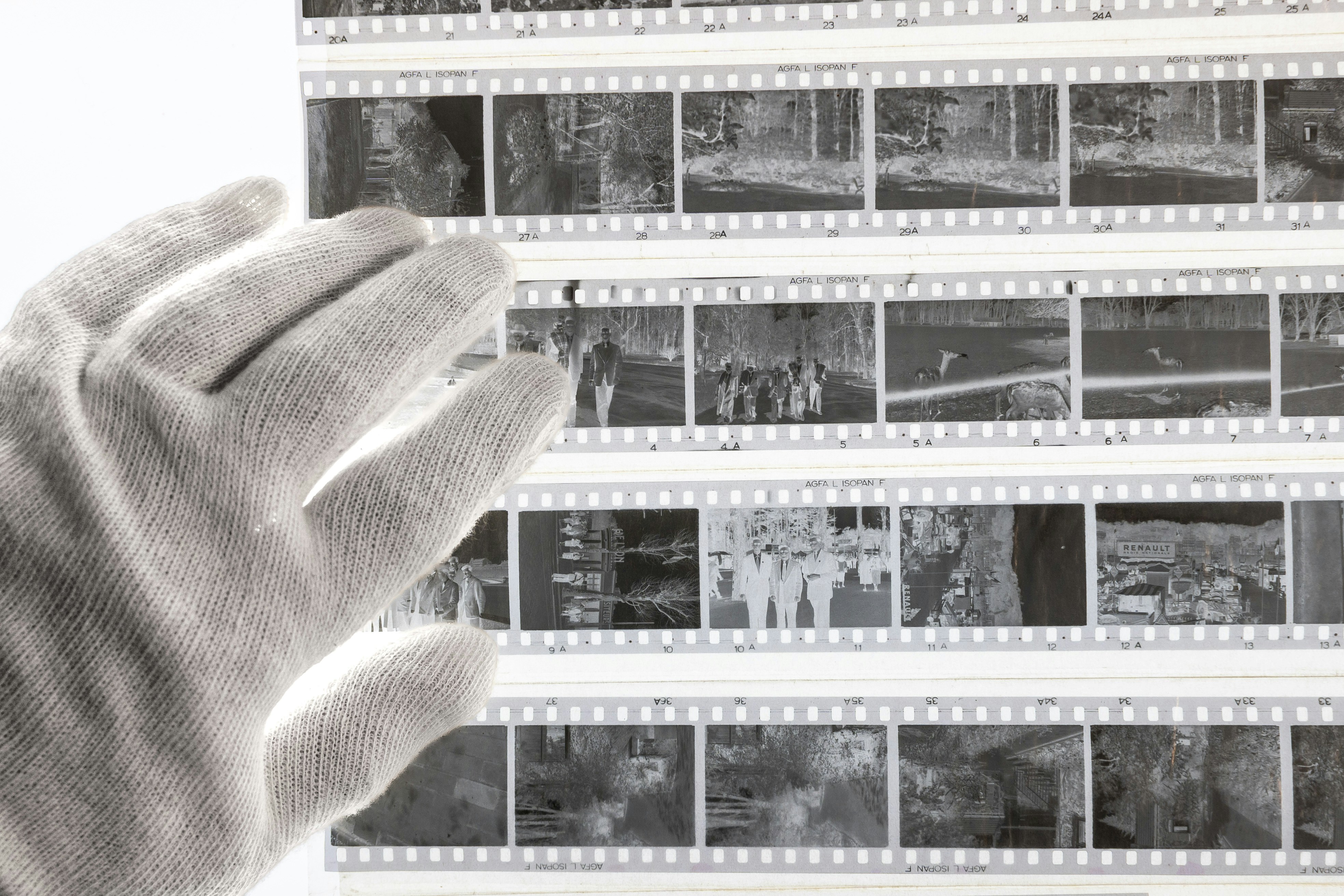 A hand holding a film strip over a wall