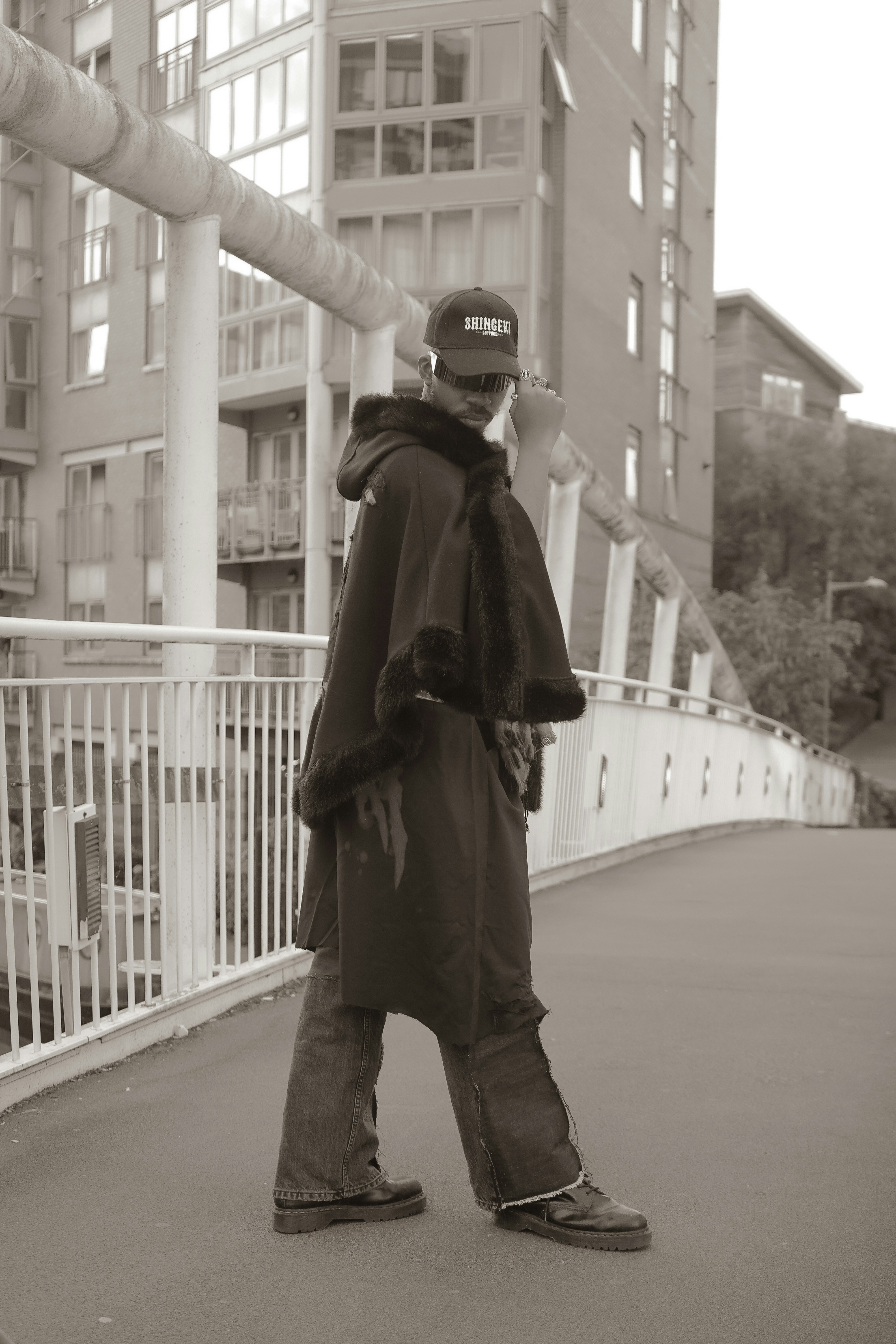 A person standing on a bridge with a skateboard