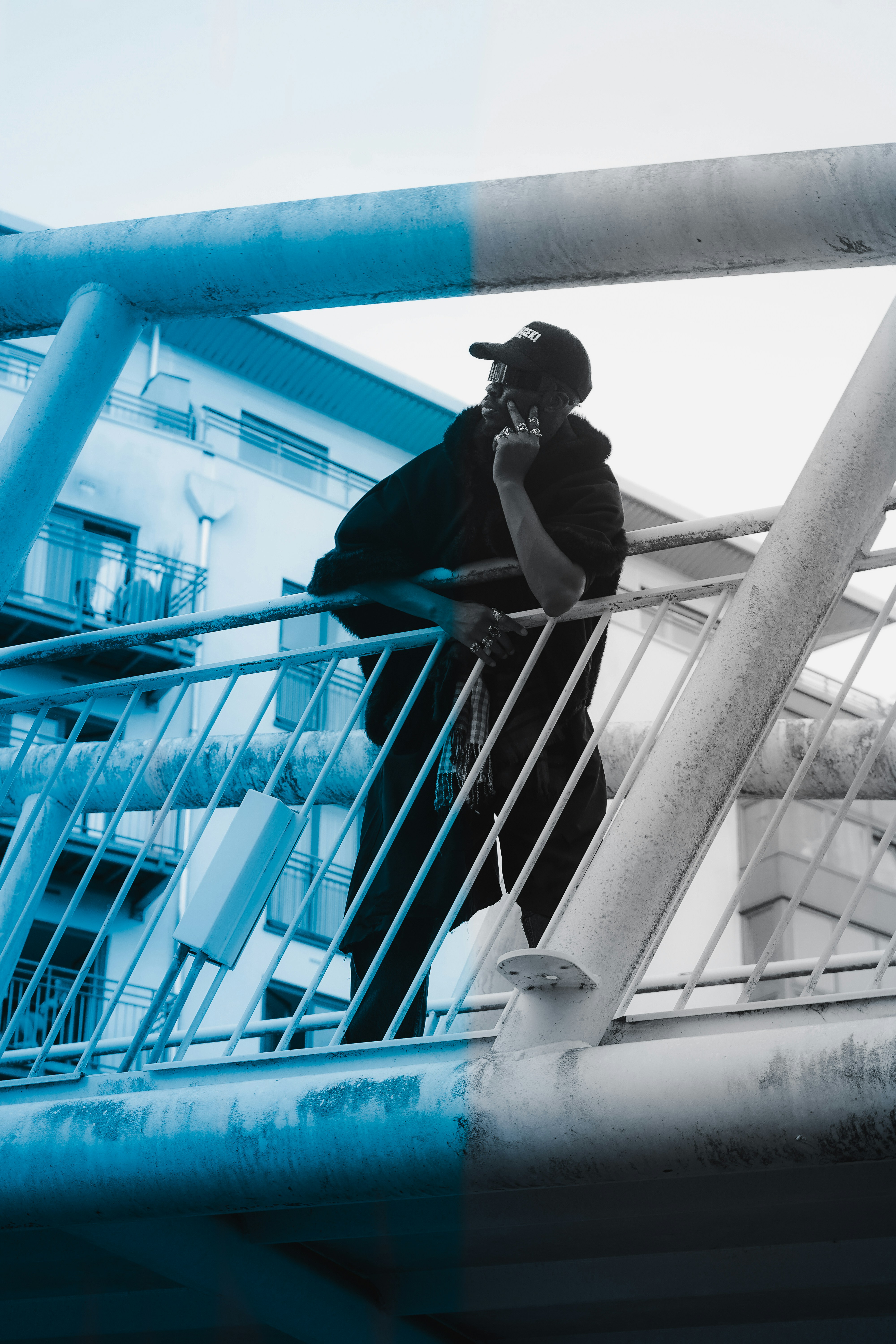 A man standing on top of a metal railing