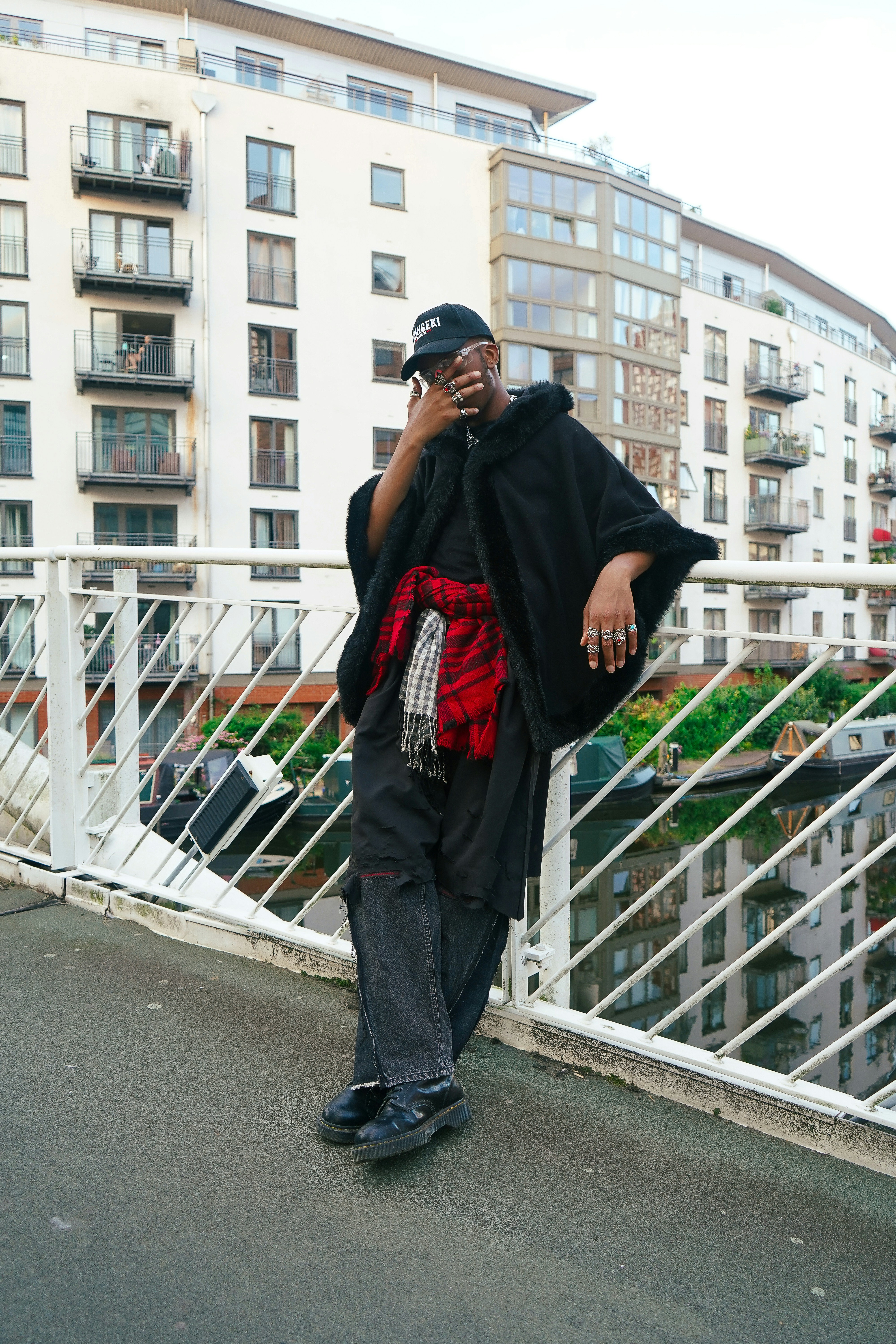A man standing on a bridge talking on a cell phone