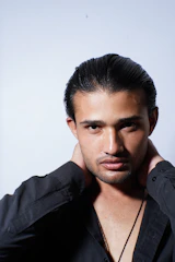 A man is posing for a picture wearing a black shirt