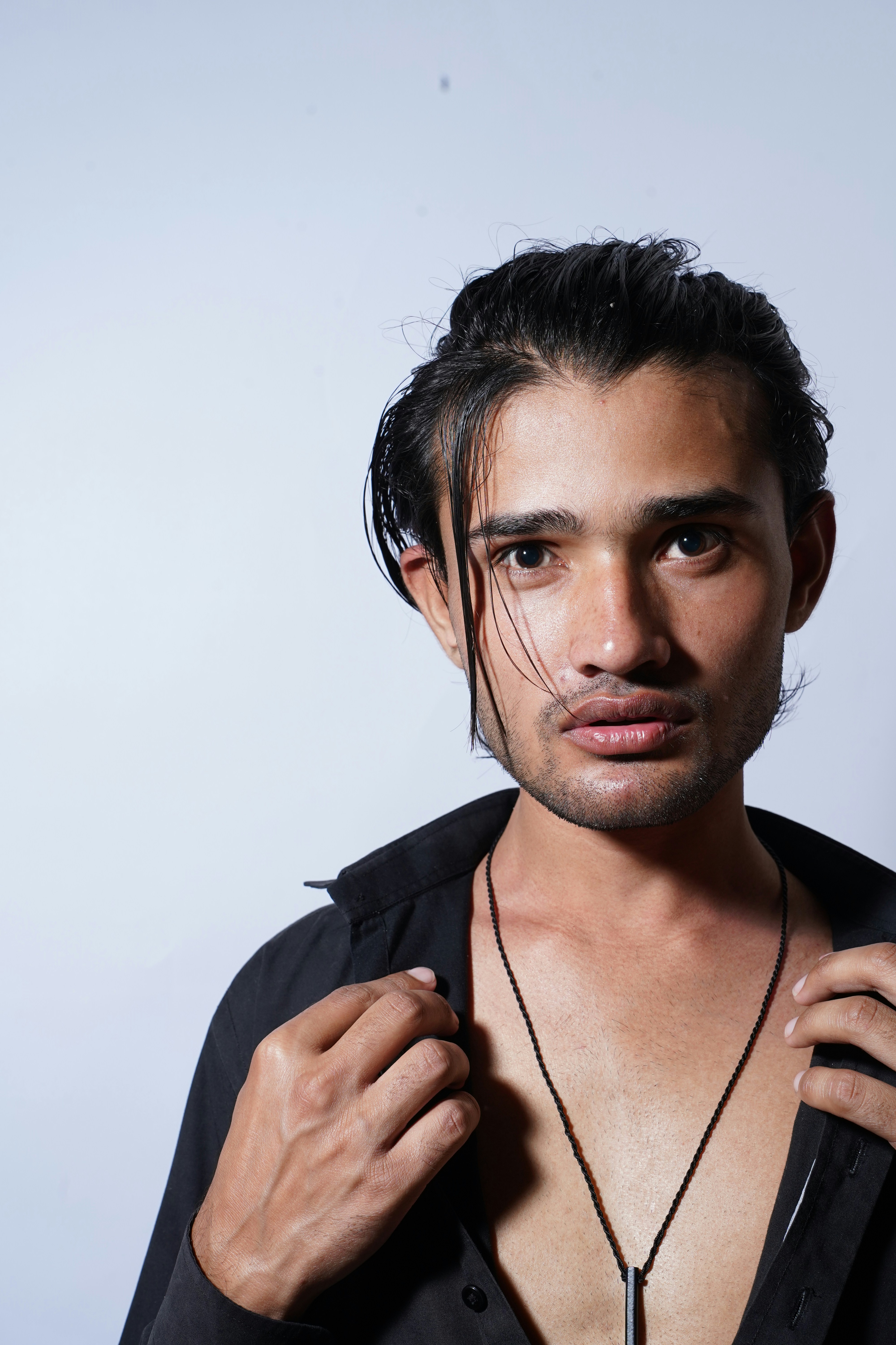 Ein Mann mit schwarzem Hemd und Halskette