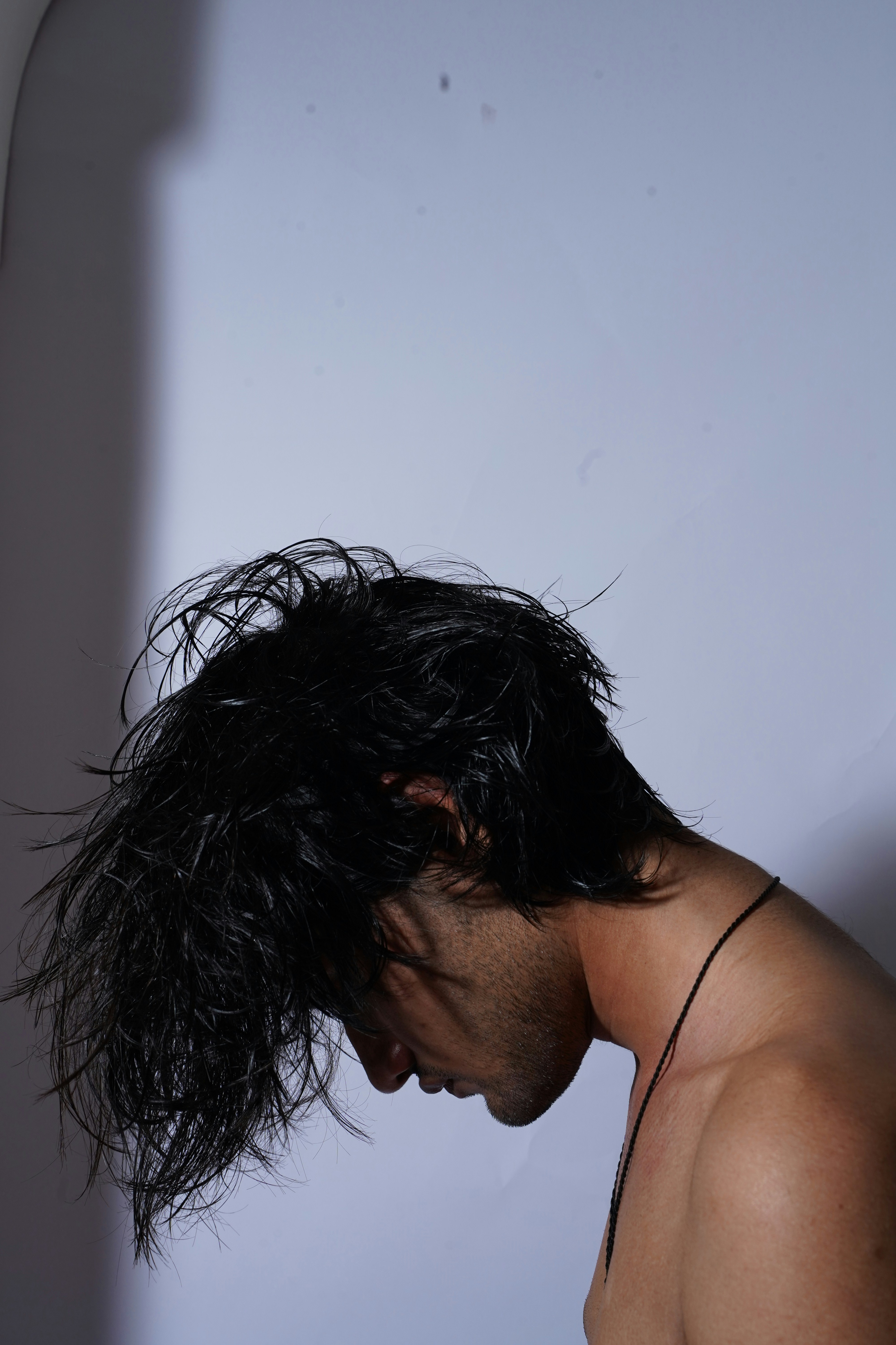 Ein Mann mit nassen Haaren steht vor einem Spiegel