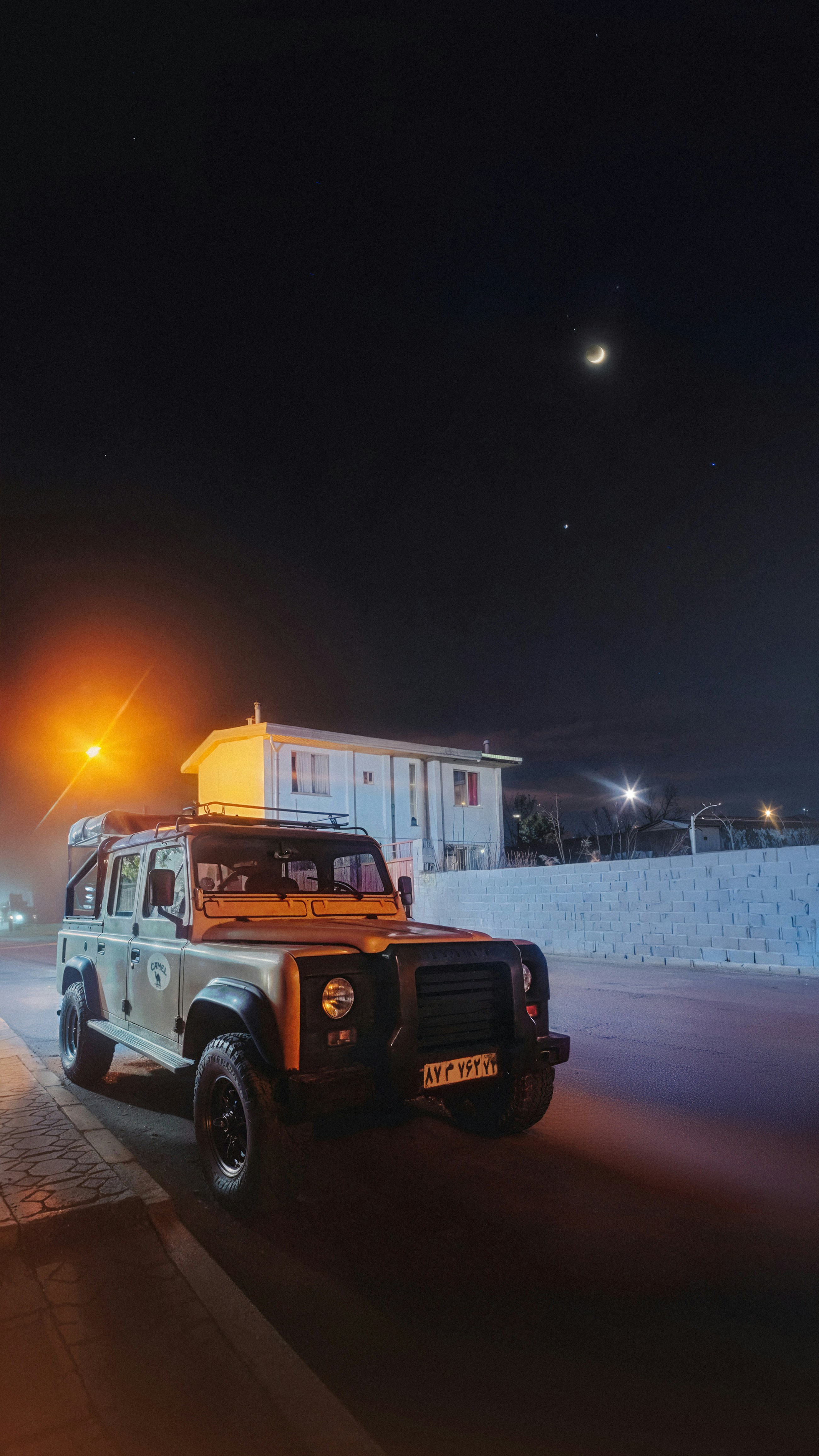 A jeep driving down a street at night