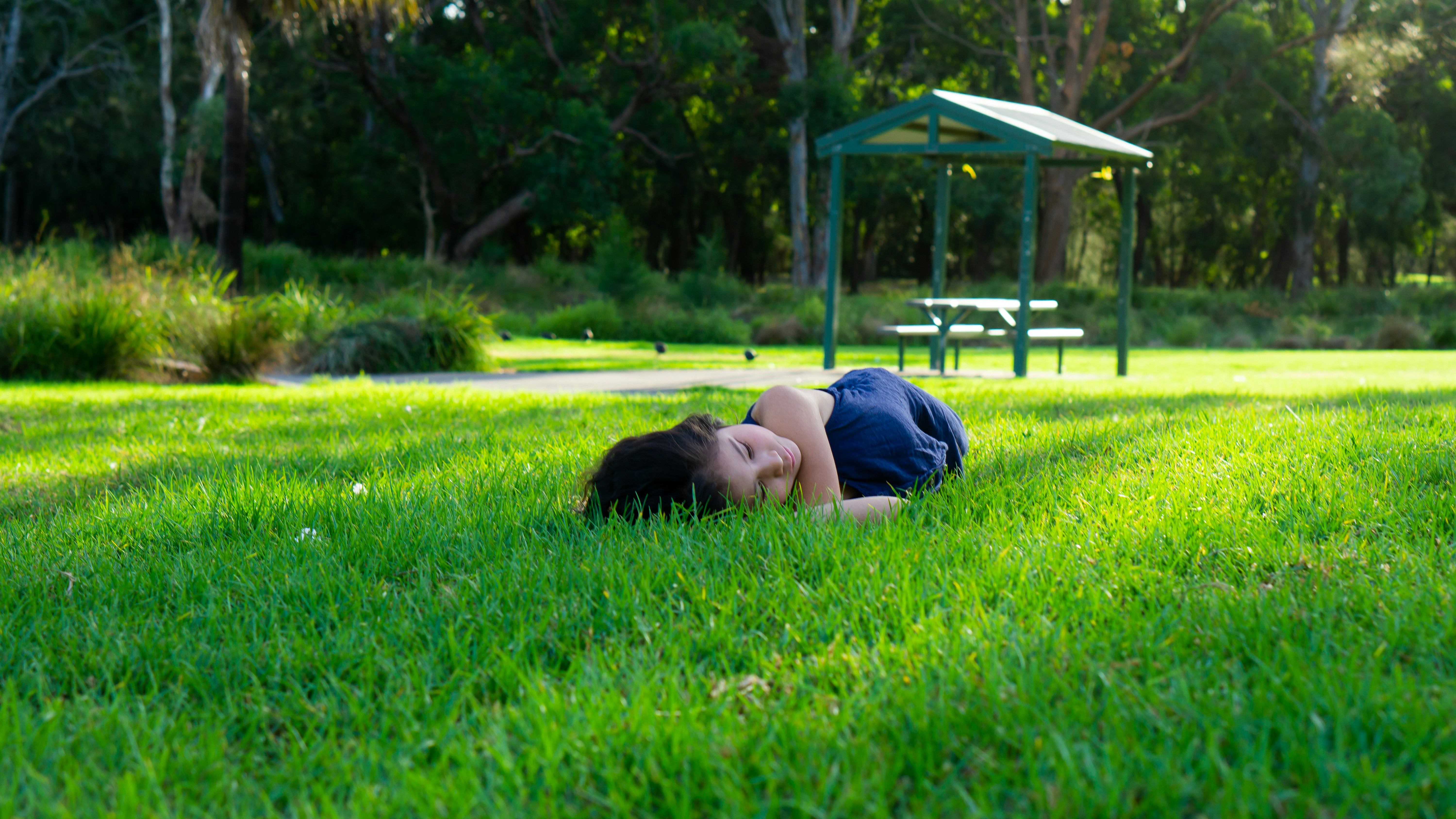 A person laying on the grass in a park