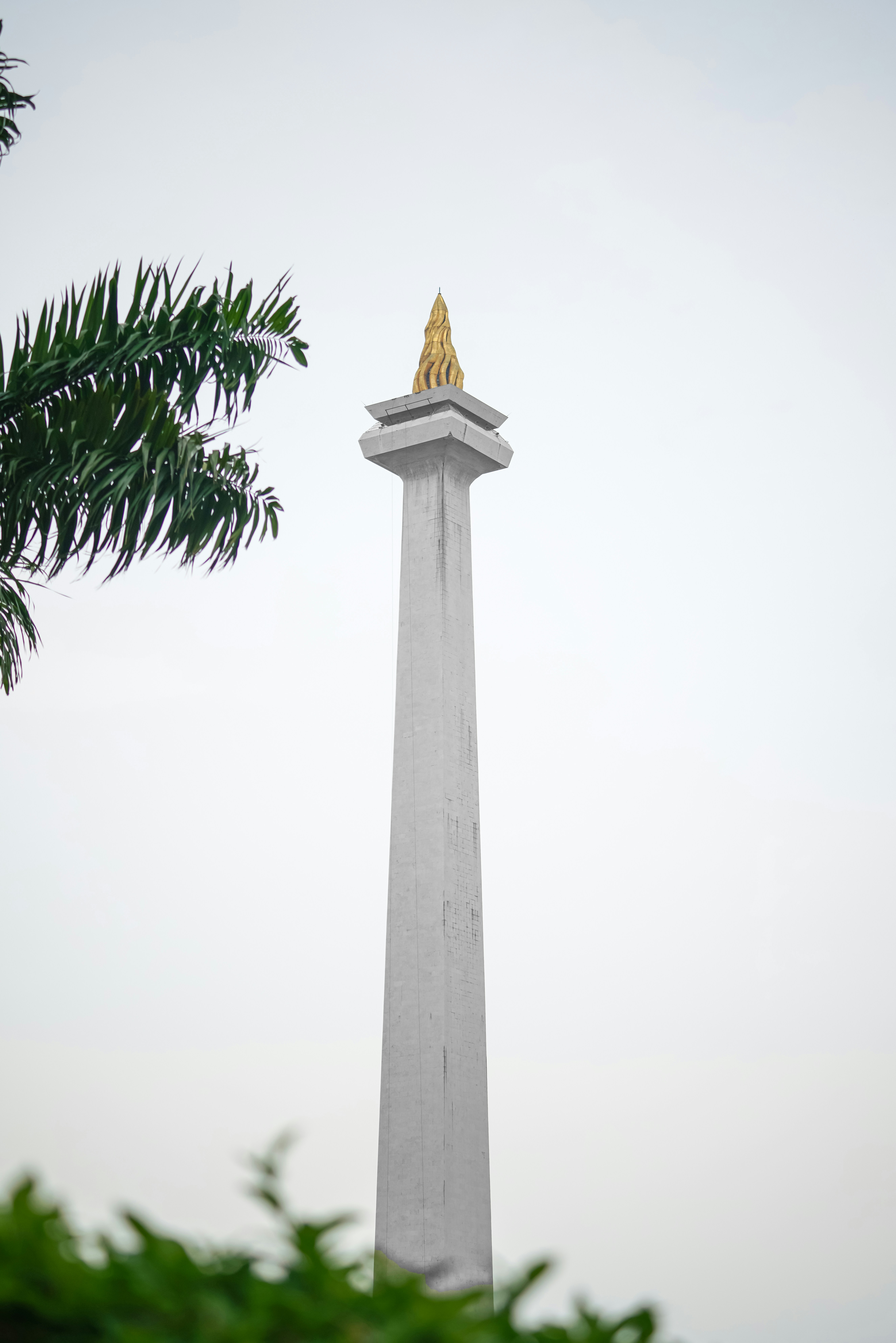 Monumen putih tinggi dengan atasan emas