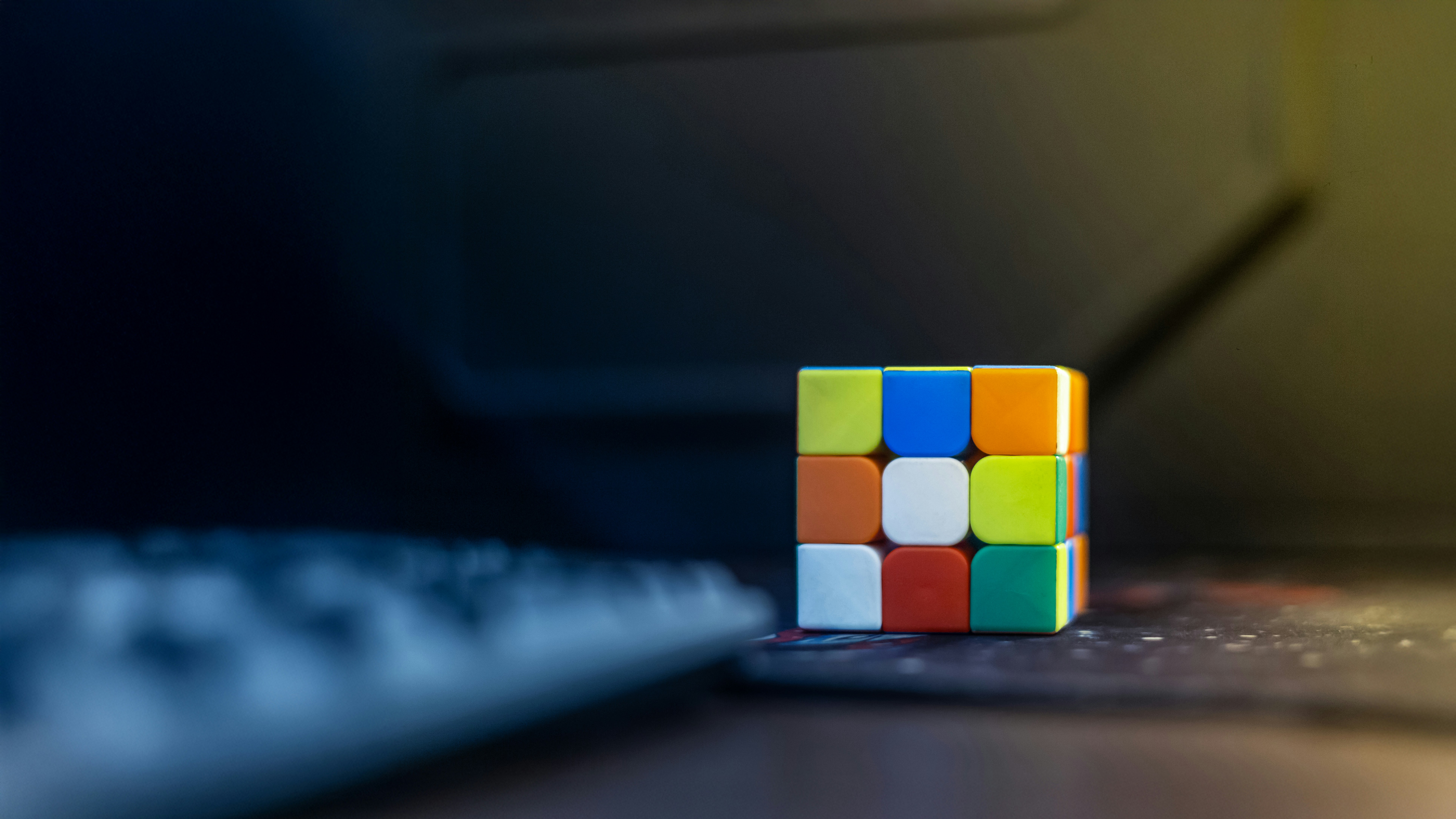 A colorful cube sitting on top of a computer keyboard