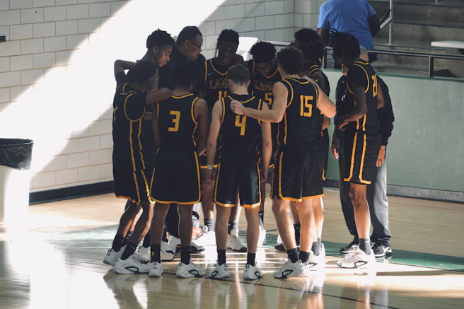 A group of young men standing on top of a basketball court