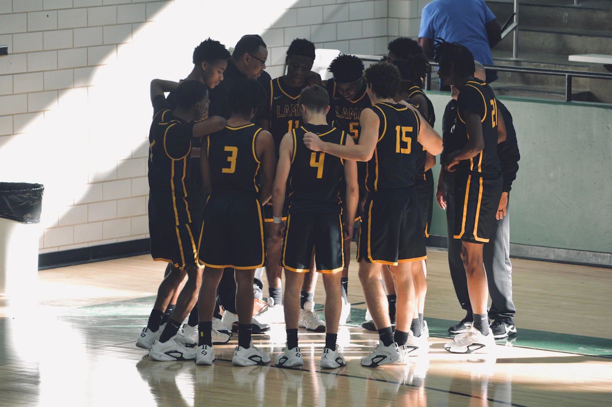A group of young men standing on top of a basketball court