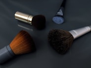 A close up of three makeup brushes on a table