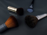 A close up of three makeup brushes on a table