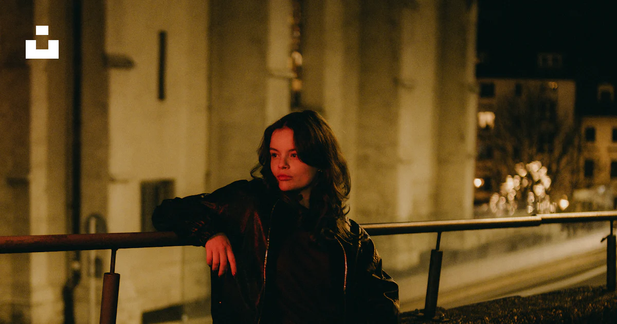 Sleeping Against Railing A woman leaning against a railing at night photo β Free City Image on ...