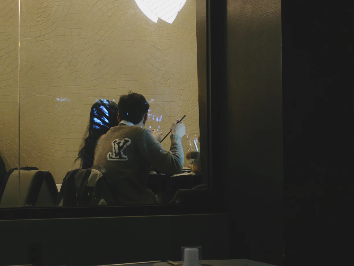 A man sitting in front of a window with an apple logo on it