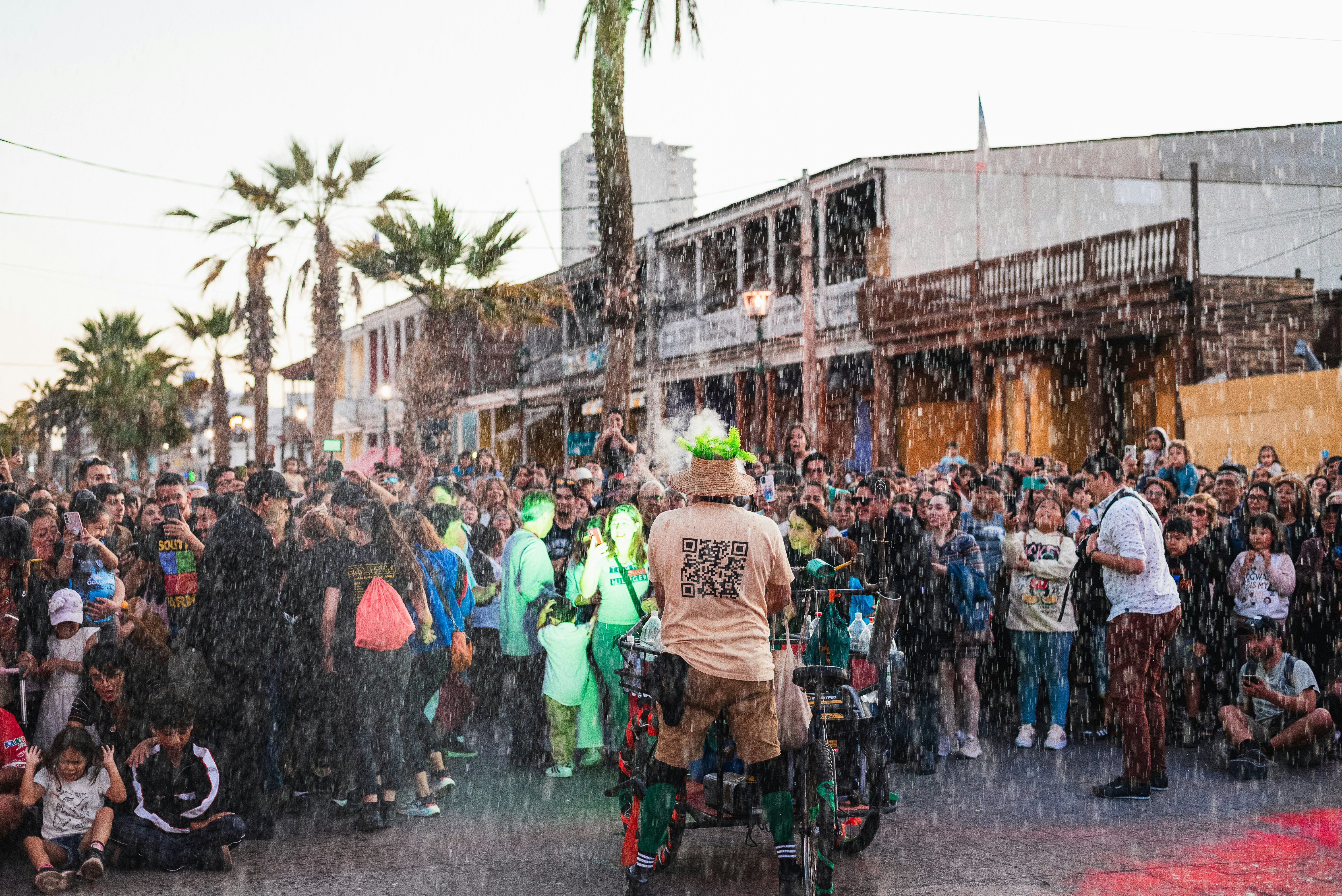 A man riding a bike down a street next to a crowd of people