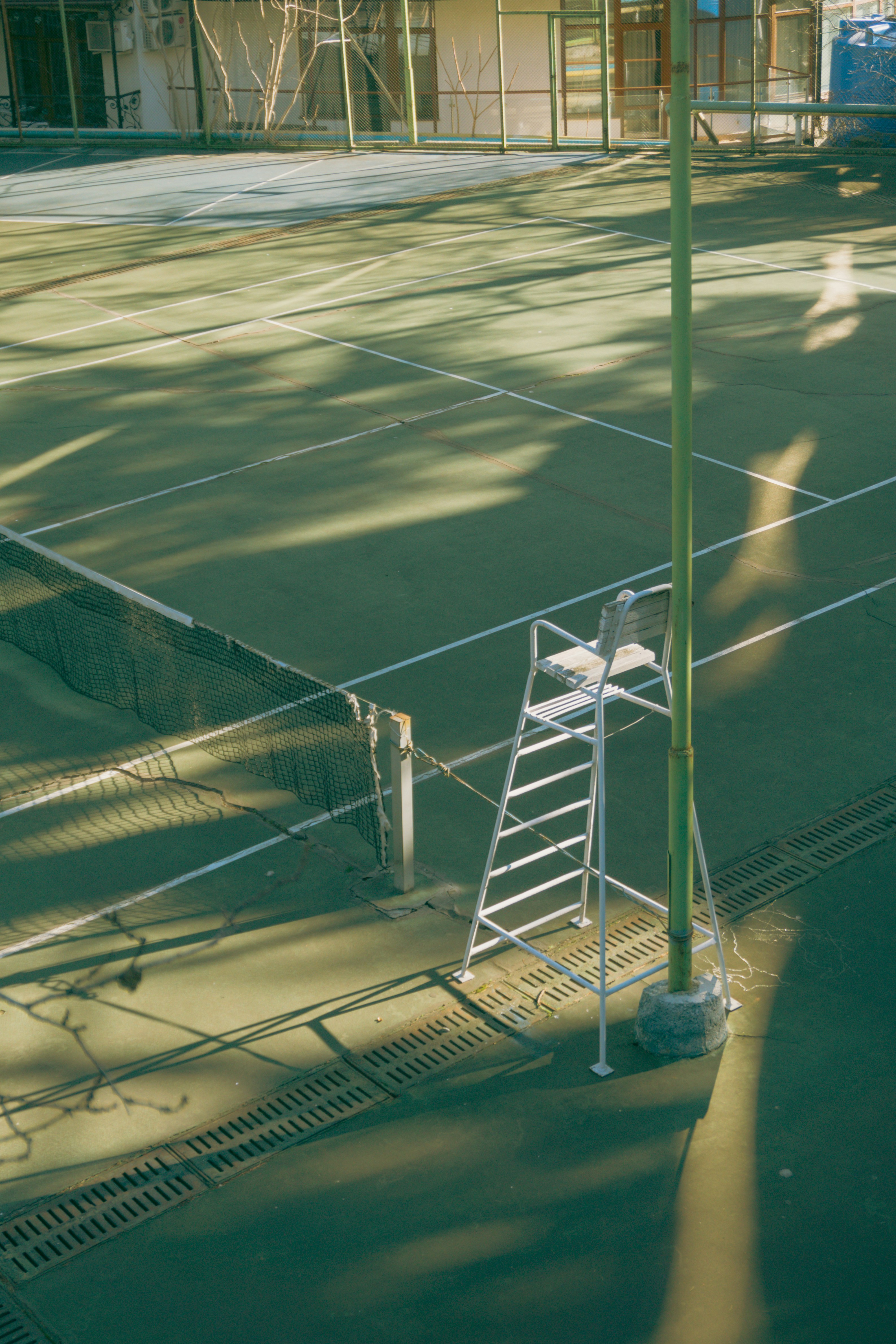 A tennis court with a ladder on the side of it