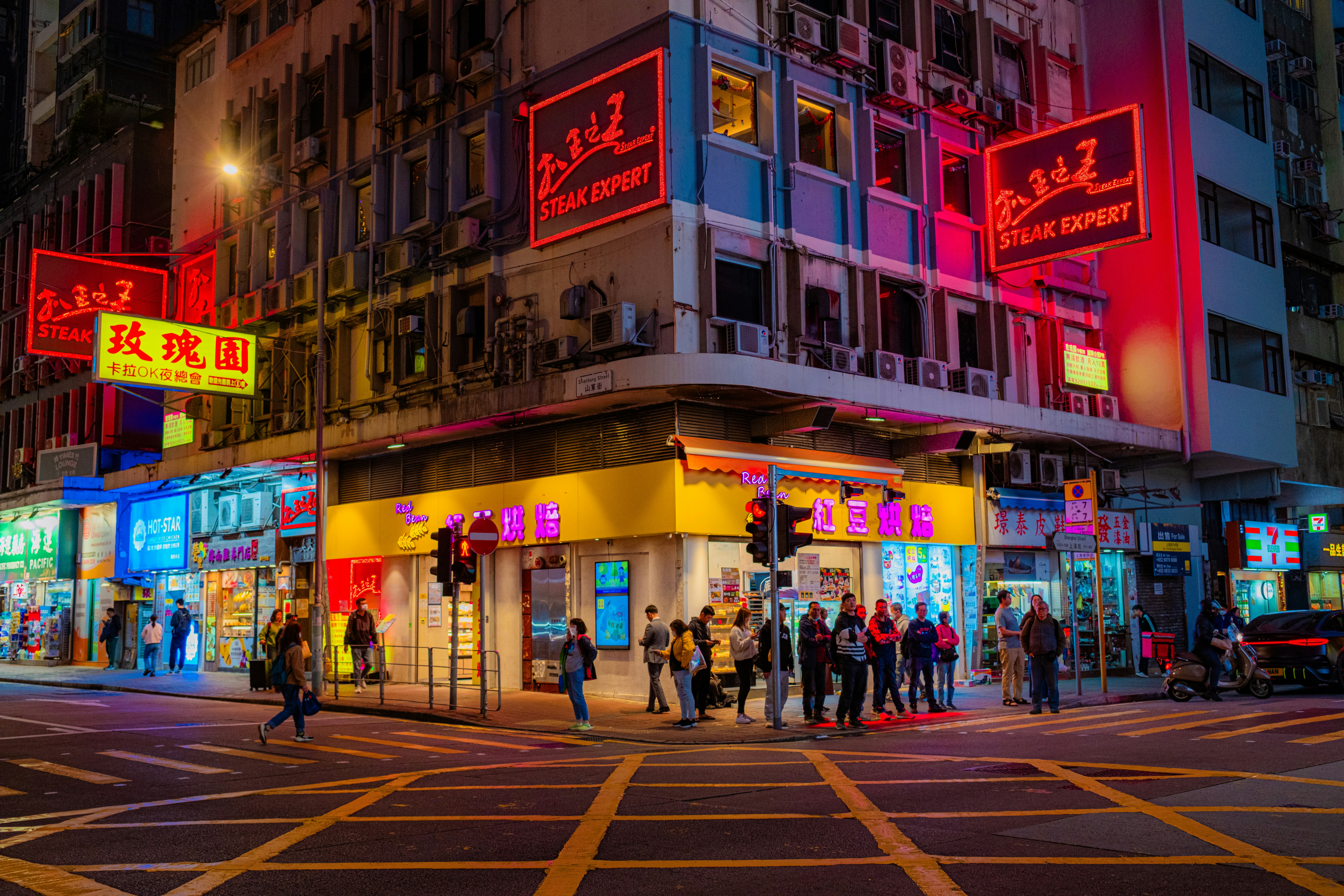 A group of people standing outside of a building at night