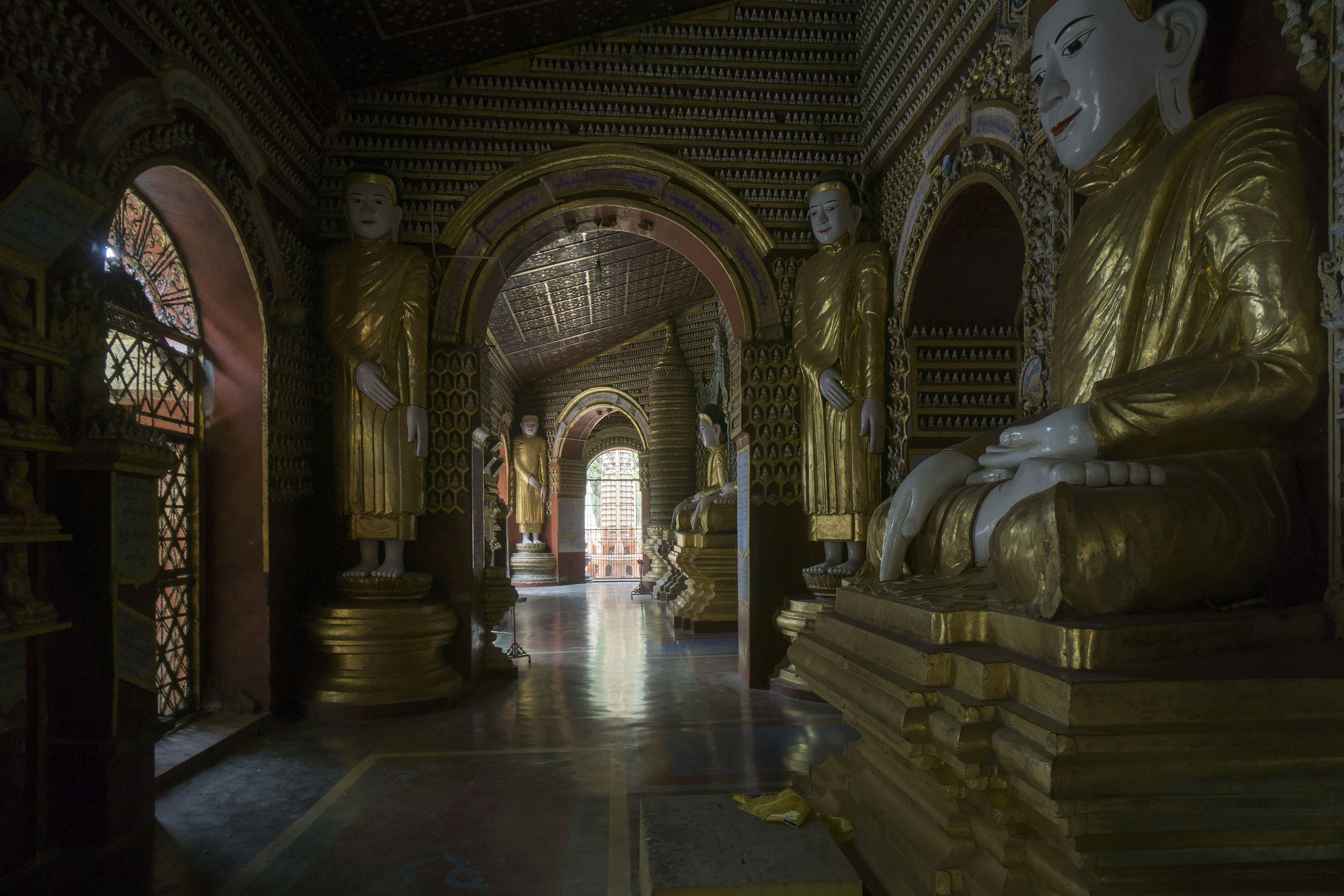 A long hallway with a statue of buddha in the center