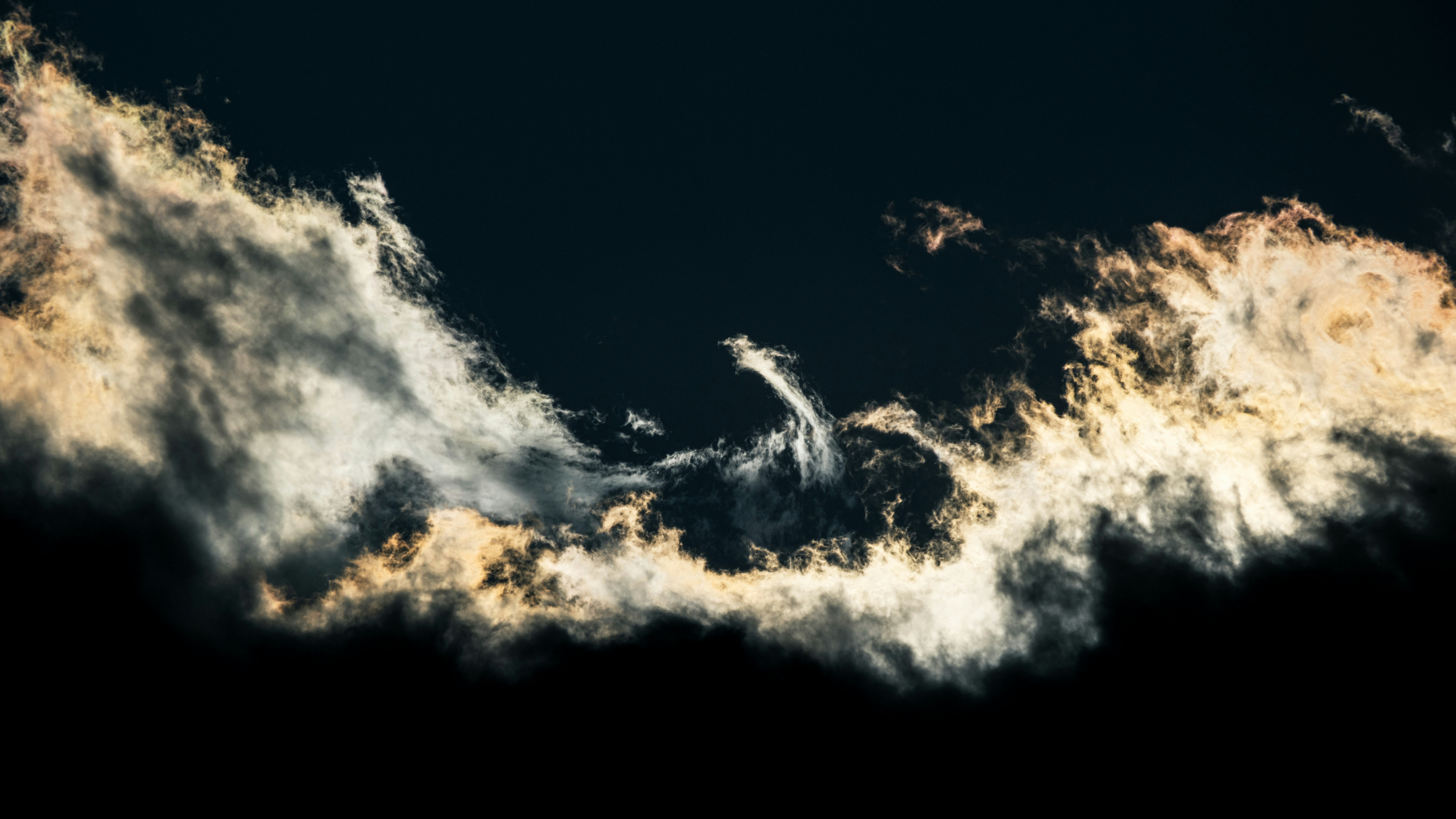 A black sky with a few clouds in it