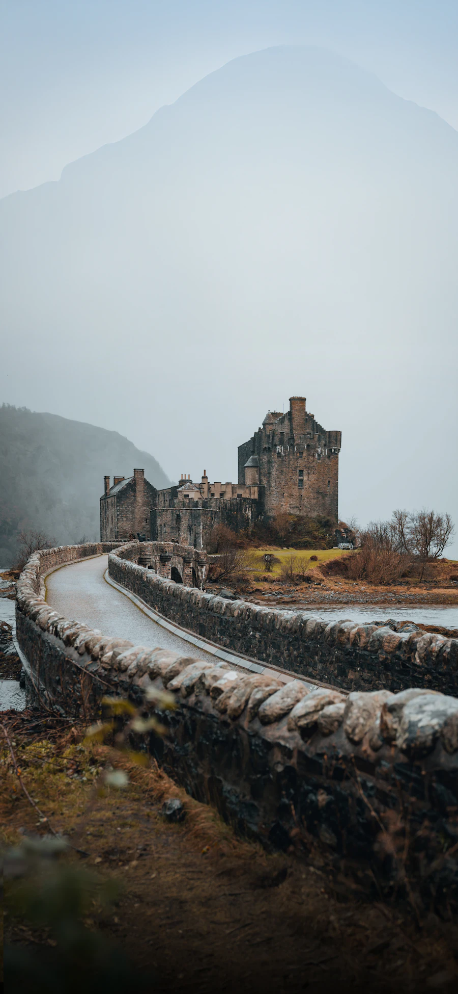 A castle on a small island joined to the shore by a stone bridge
