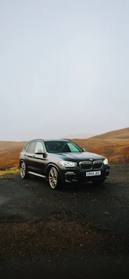 A black car parked on a gravel road
