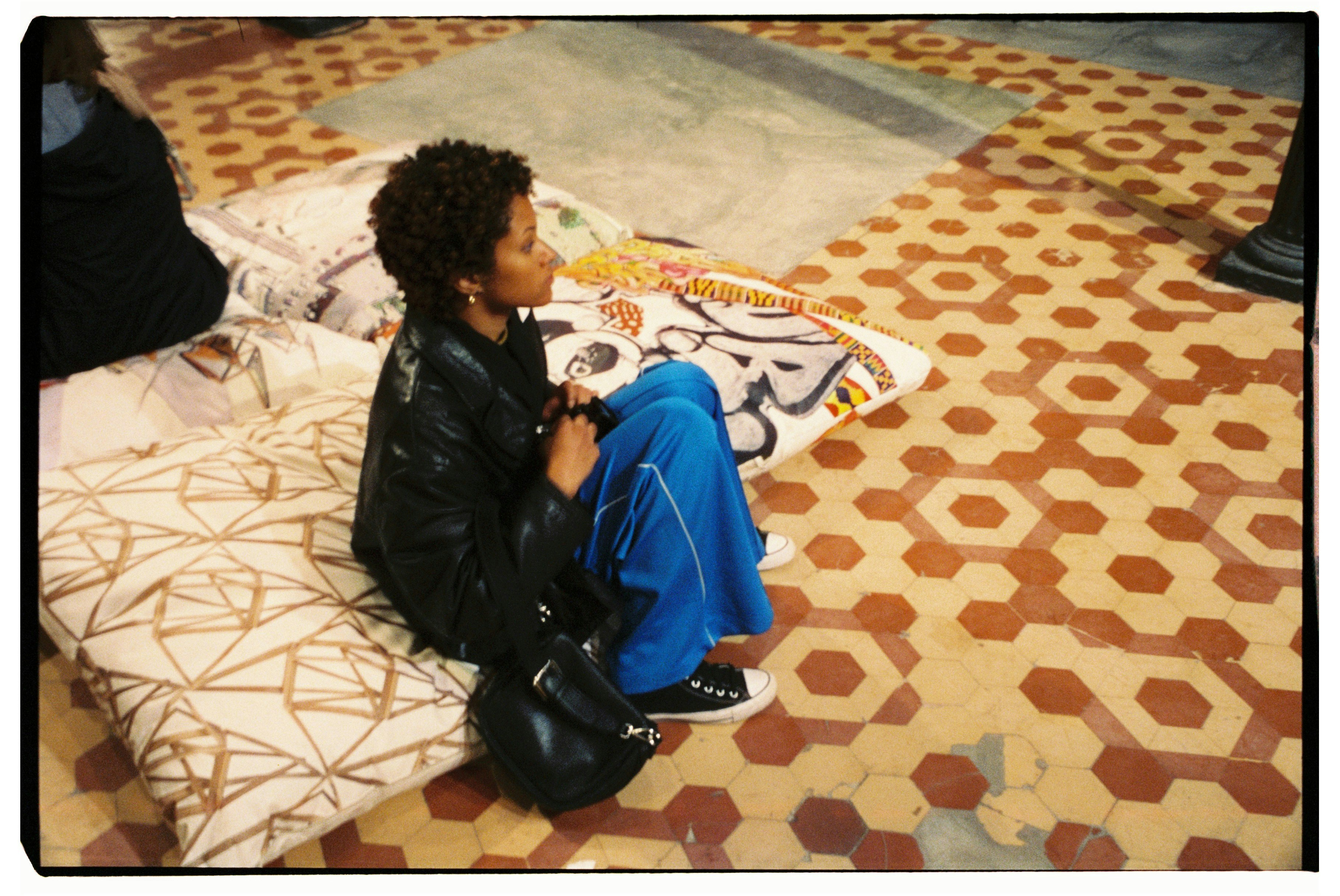 A person sitting on a bed with a bag