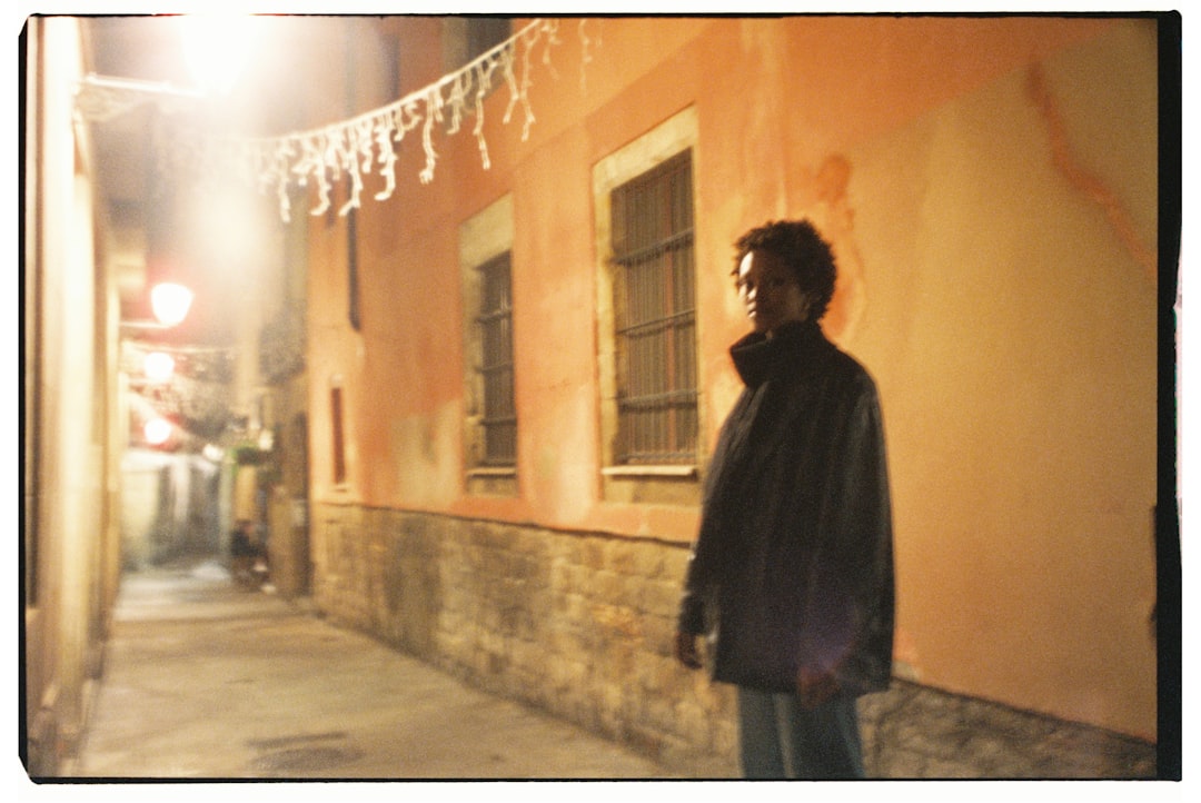 A man standing on a sidewalk next to a building,