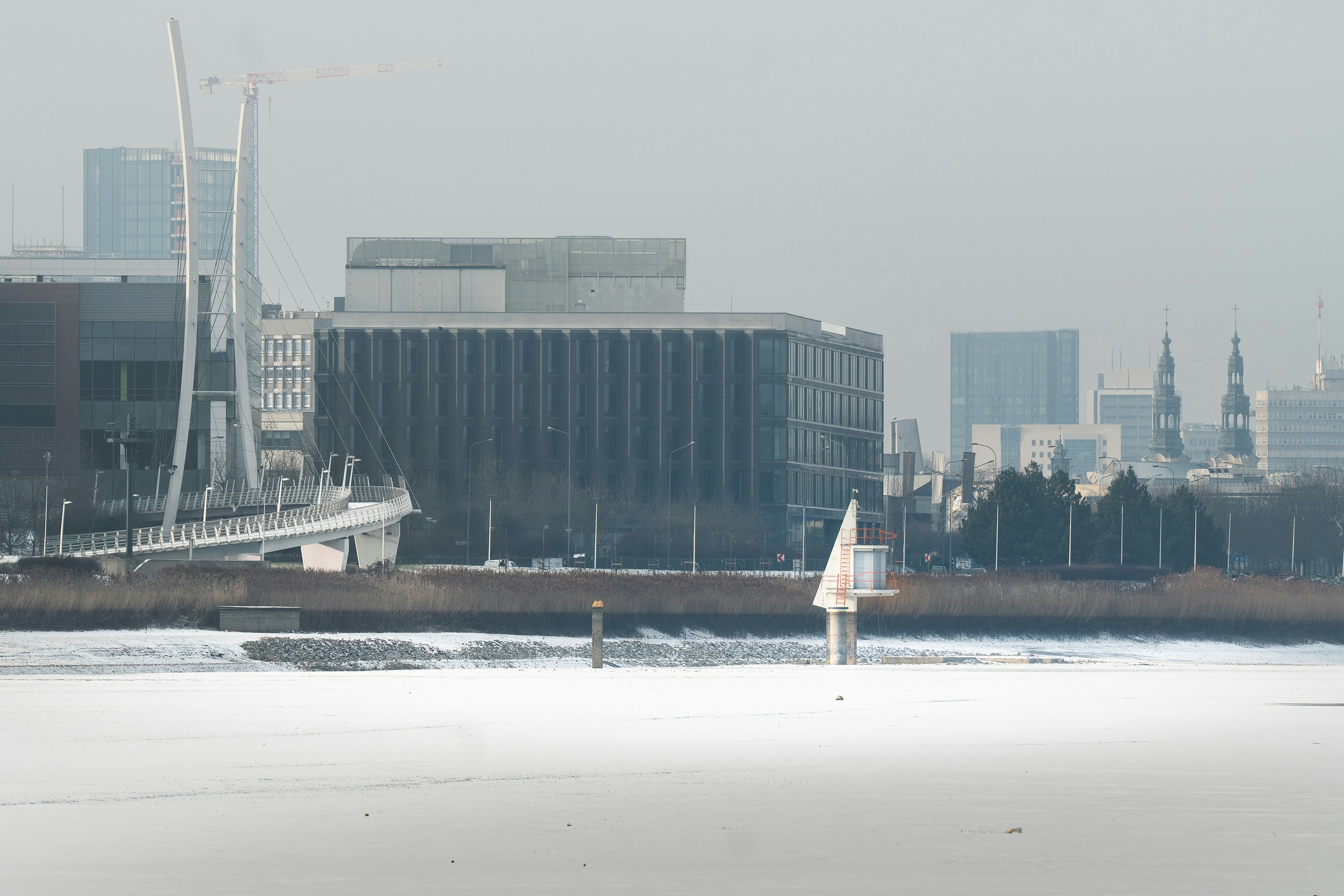 A sailboat in a body of water with a city in the background
