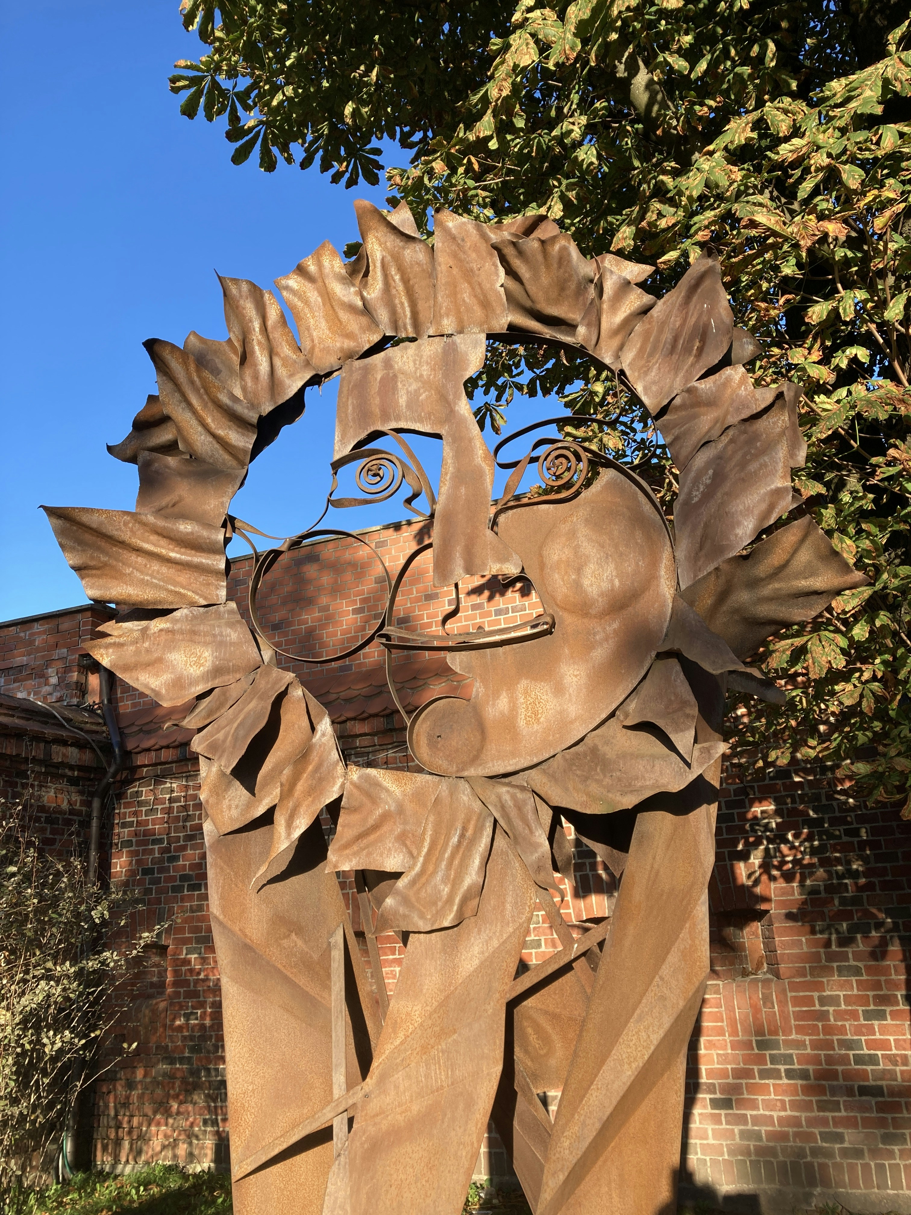 A sculpture of a woman's face in front of a building
