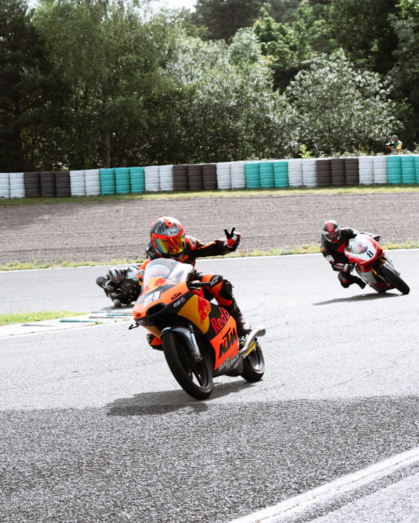 A group of people riding motorcycles on a race track