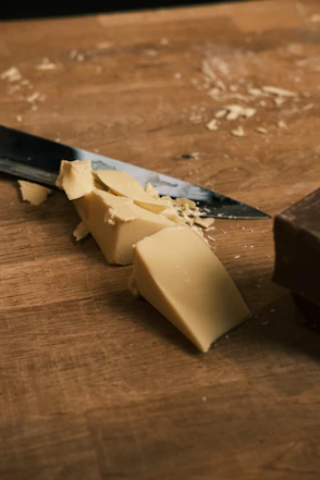 A knife and a block of butter on a cutting board
