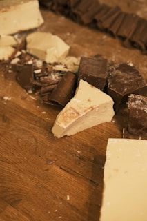 A wooden table topped with lots of pieces of chocolate