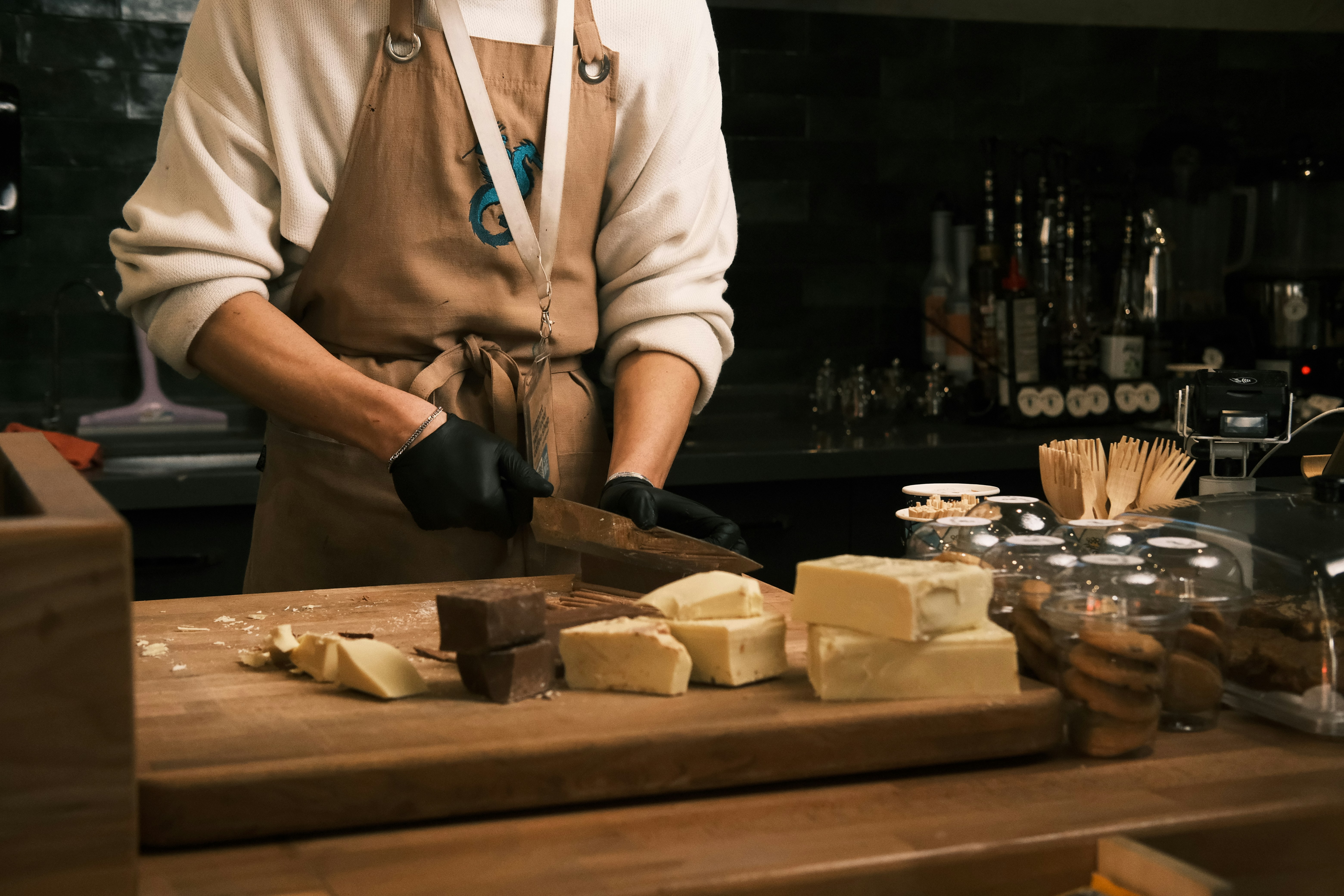 A man standing in front of a cutting board with cheese on it