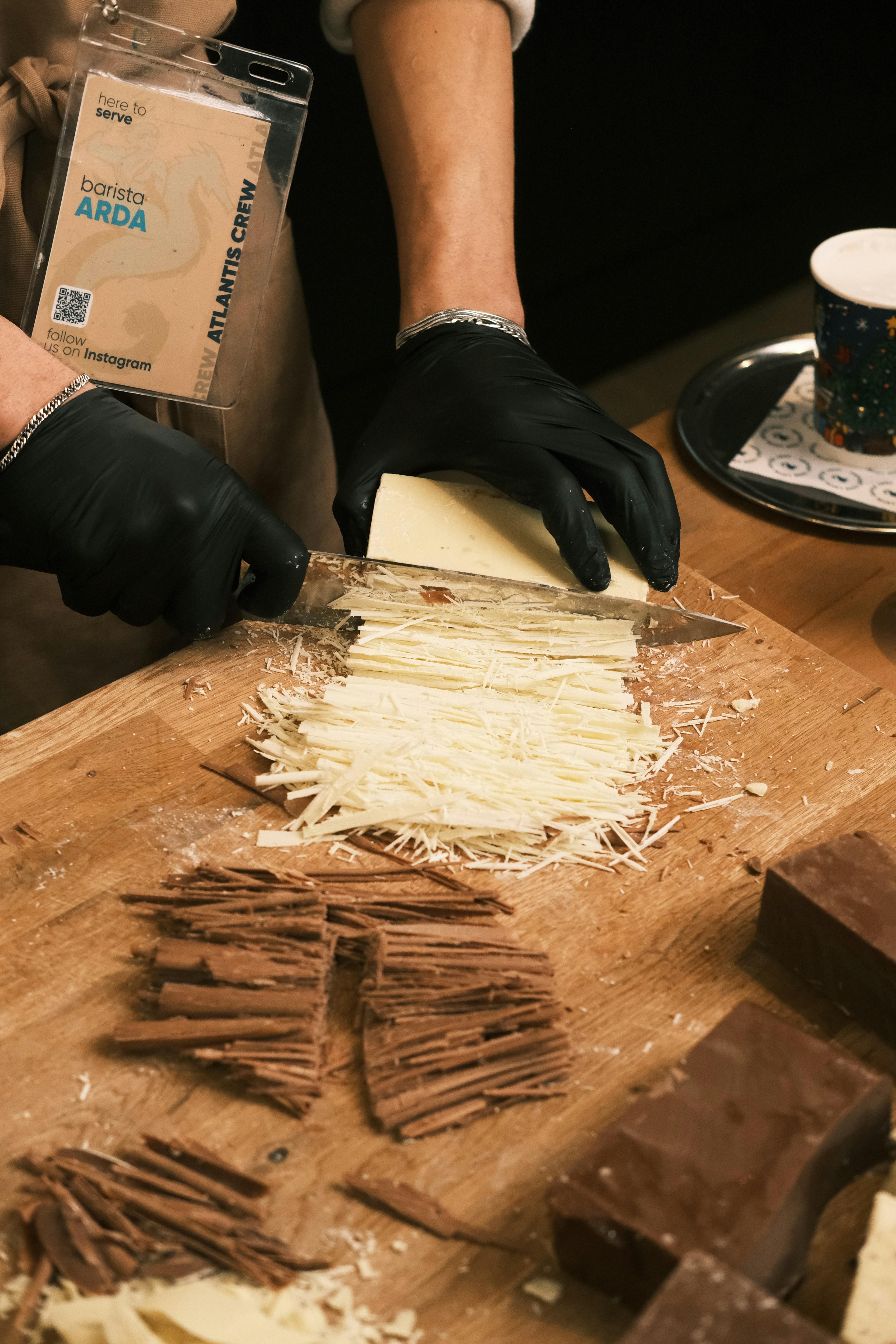 Barista cutting white chocolate for gourmet recipes