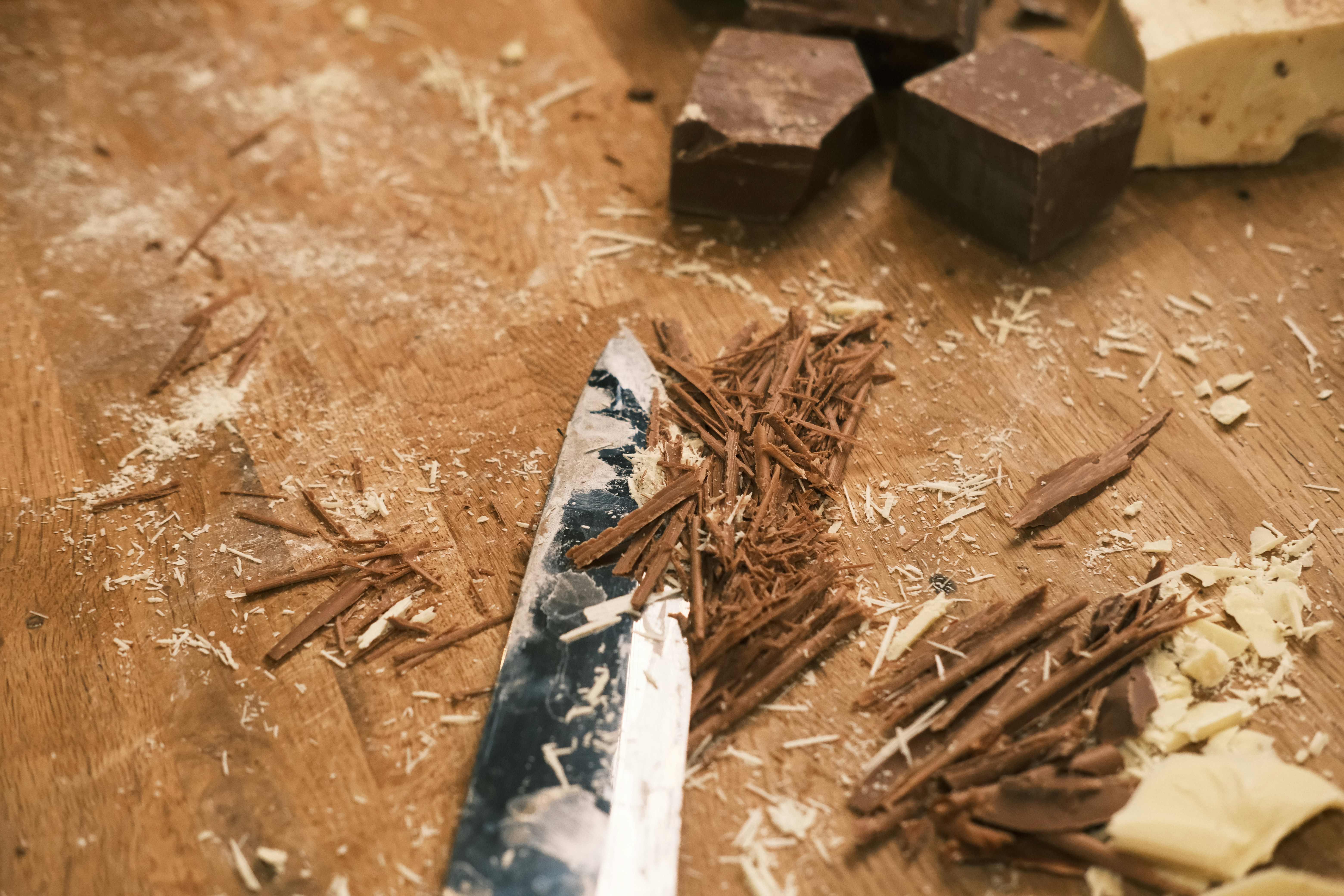 A knife on a wooden table next to a knife blade