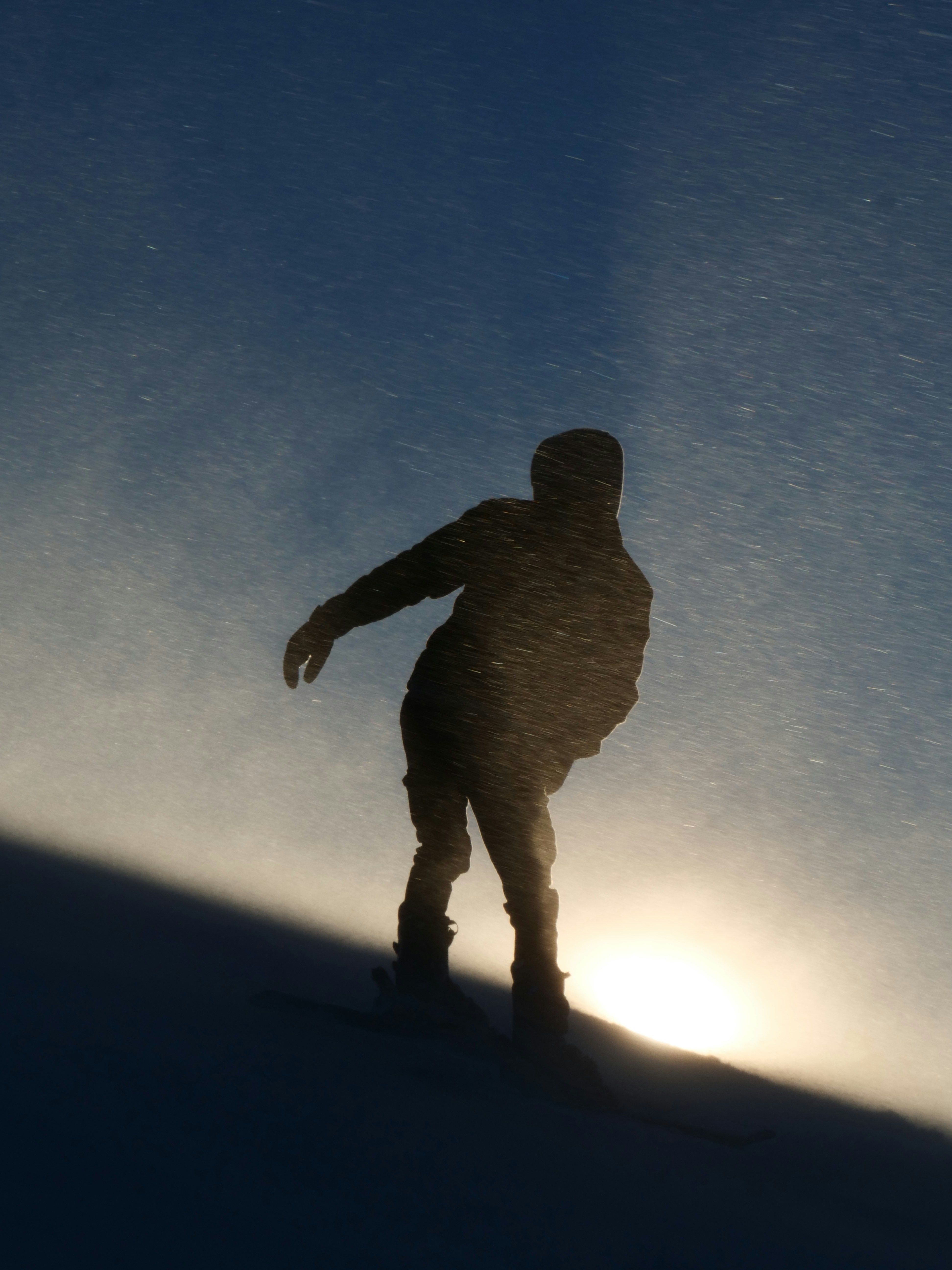 A person riding a snowboard down a snow covered slope
