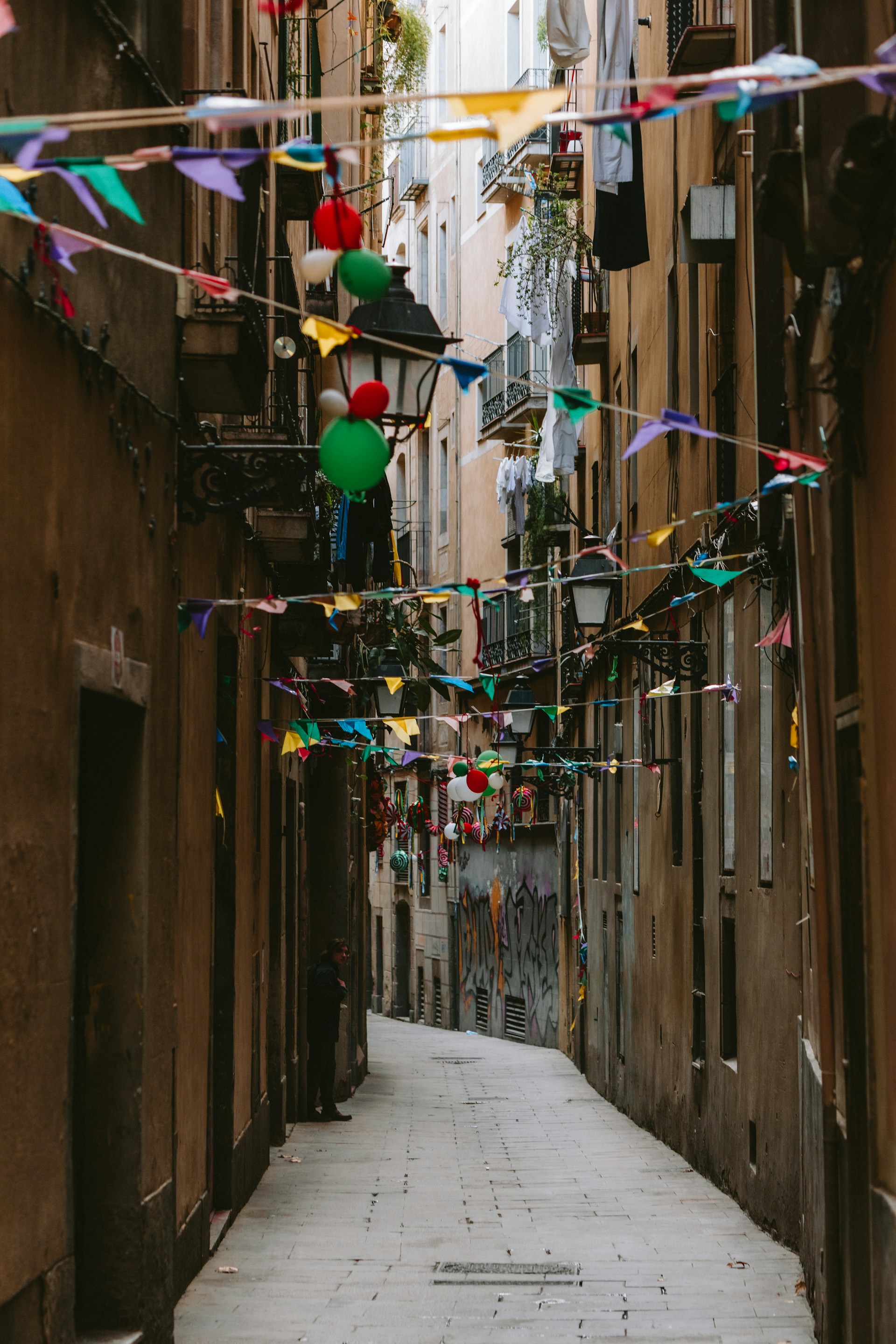 A narrow alleyway with flags and bunting
