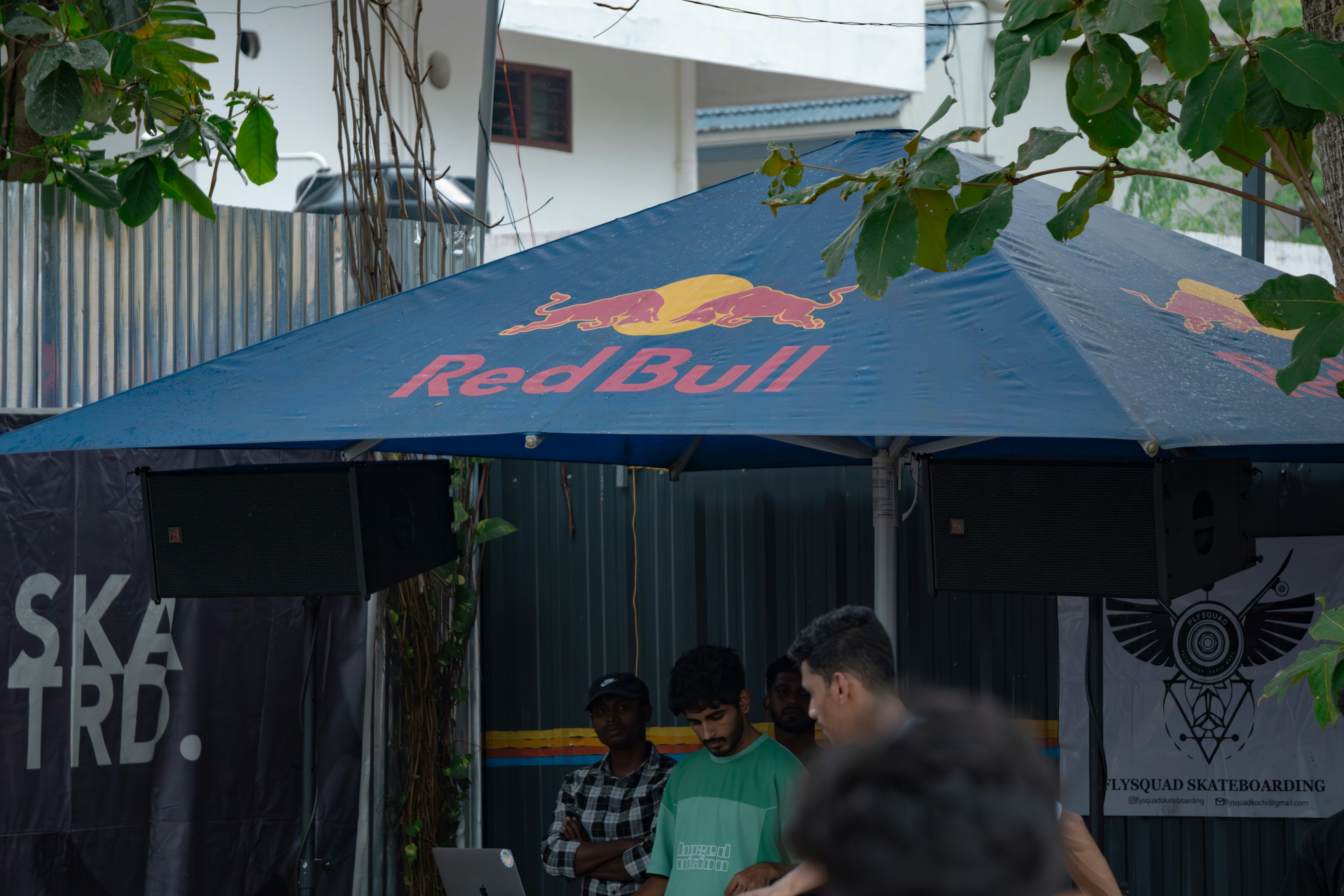 A group of people standing under a red bull tent