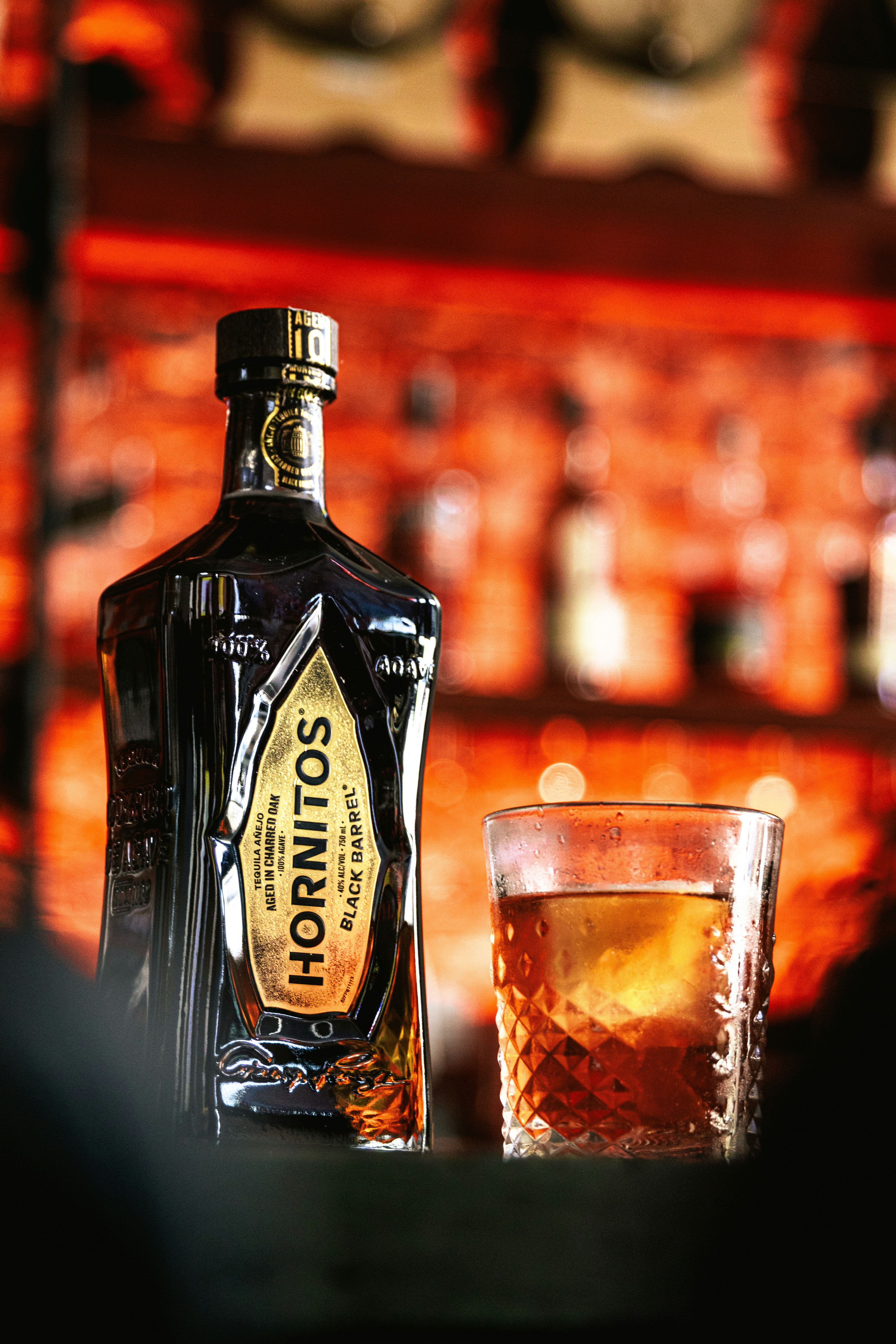 Una botella de licor junto a un vaso