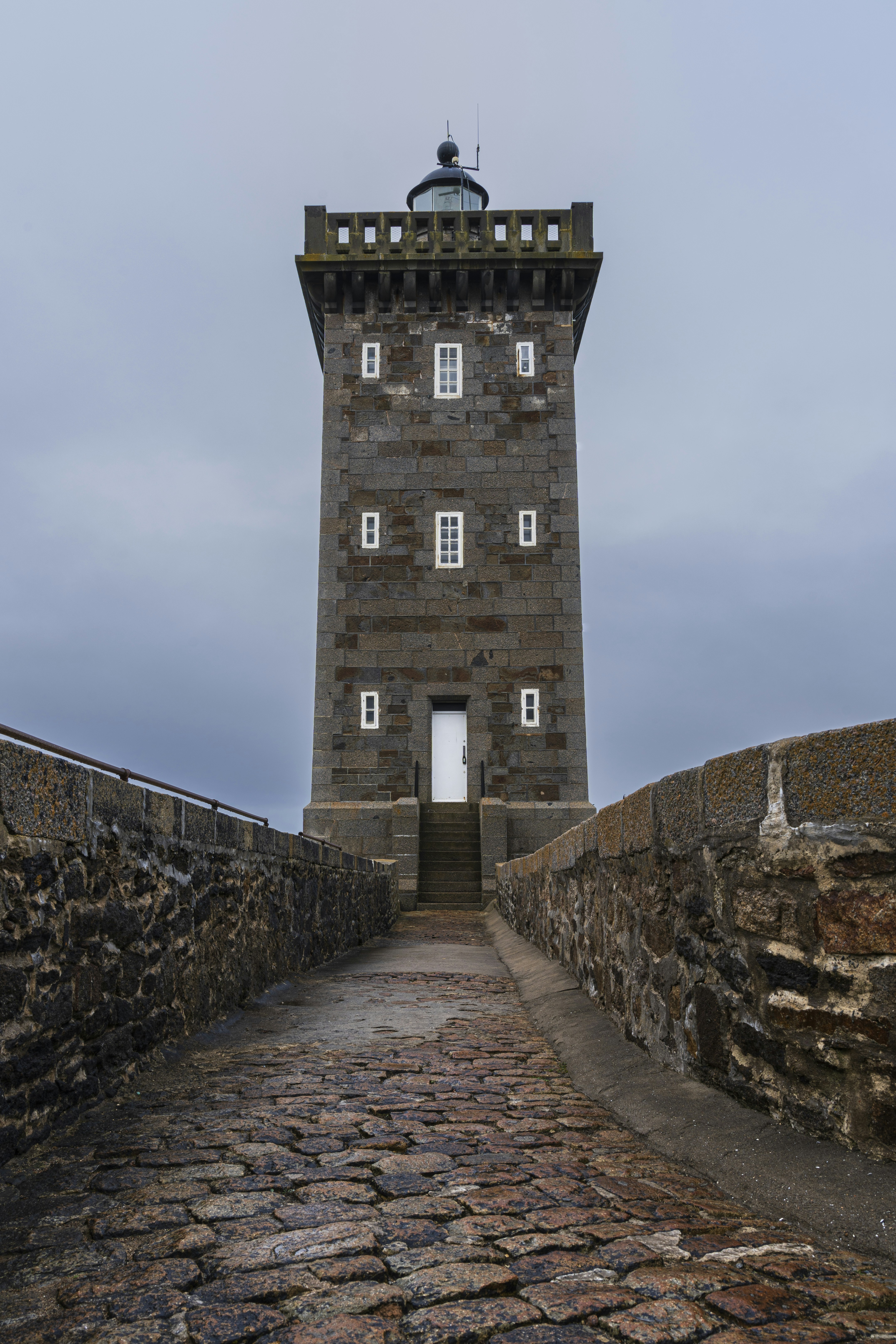 A stone walkway leading to a tall tower