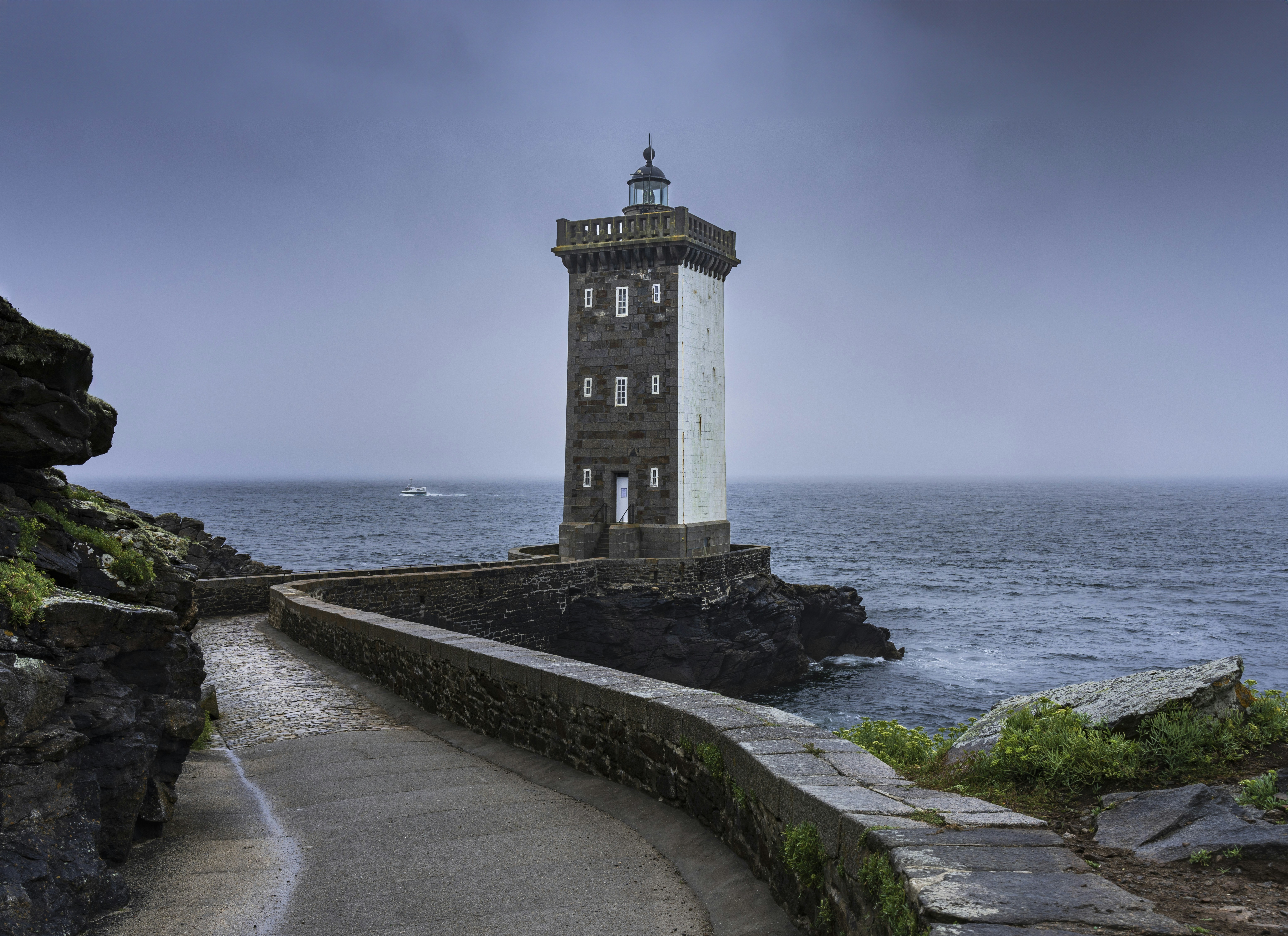 A light house sitting on top of a cliff next to the ocean