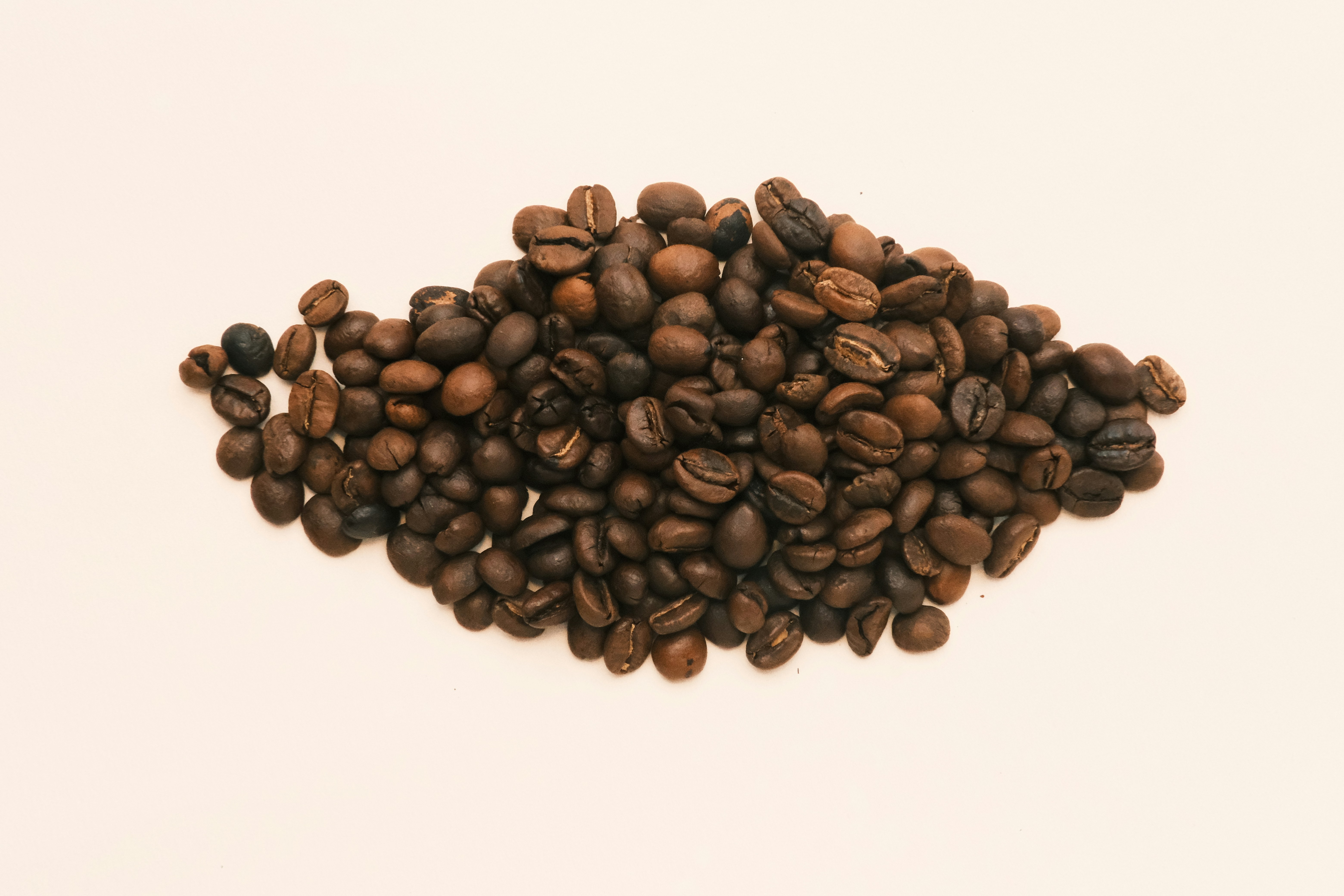 A pile of coffee beans on a white background