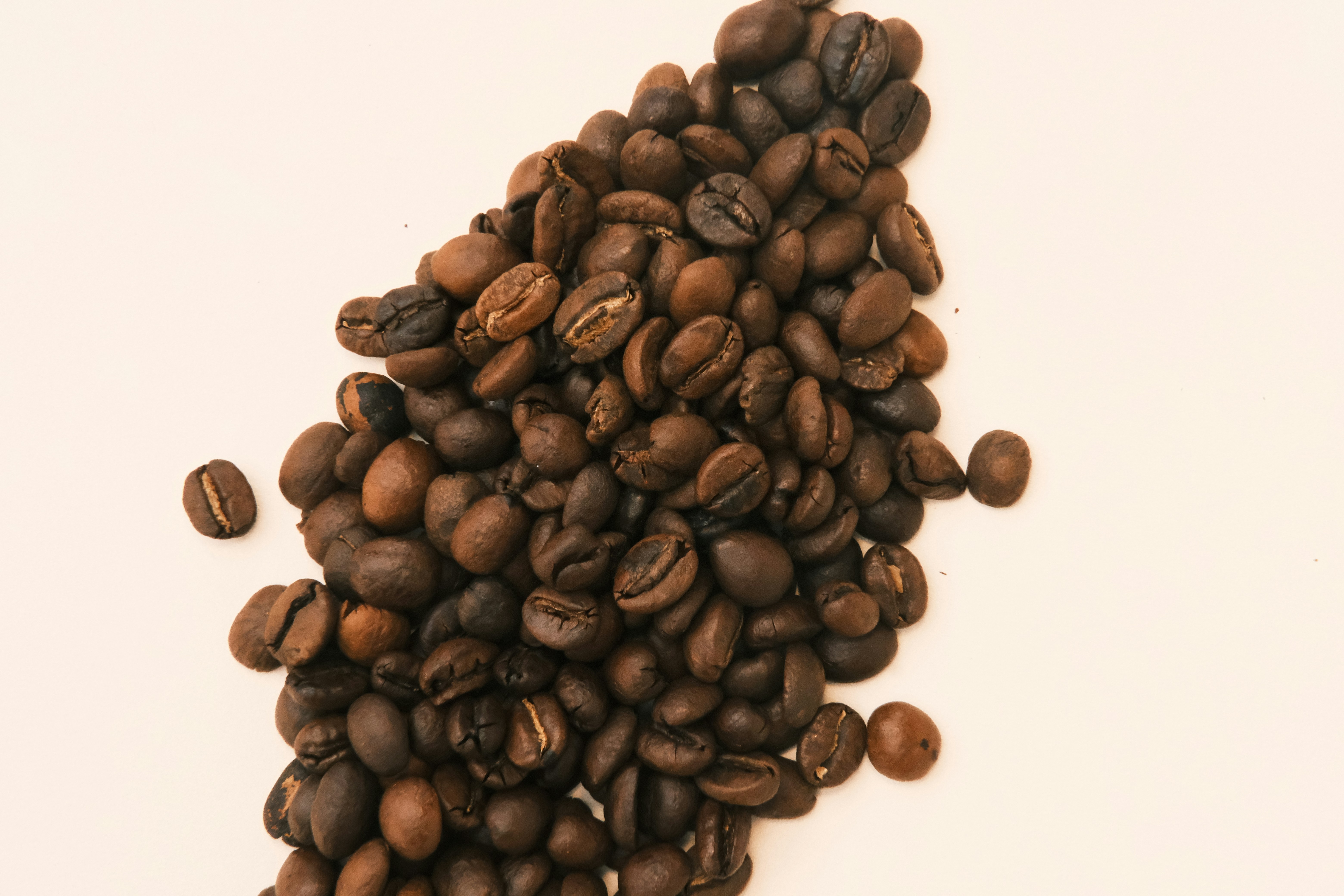 A pile of coffee beans on a white background