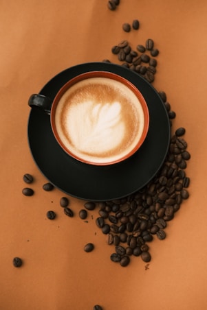 A cup of coffee surrounded by coffee beans